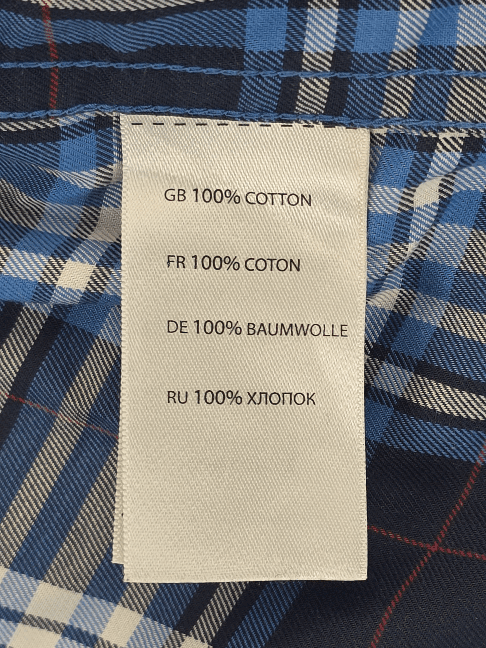 Material content tag listing cotton and polyester blend for Oak Hill blue and white plaid wrinkle-free button-up shirt.