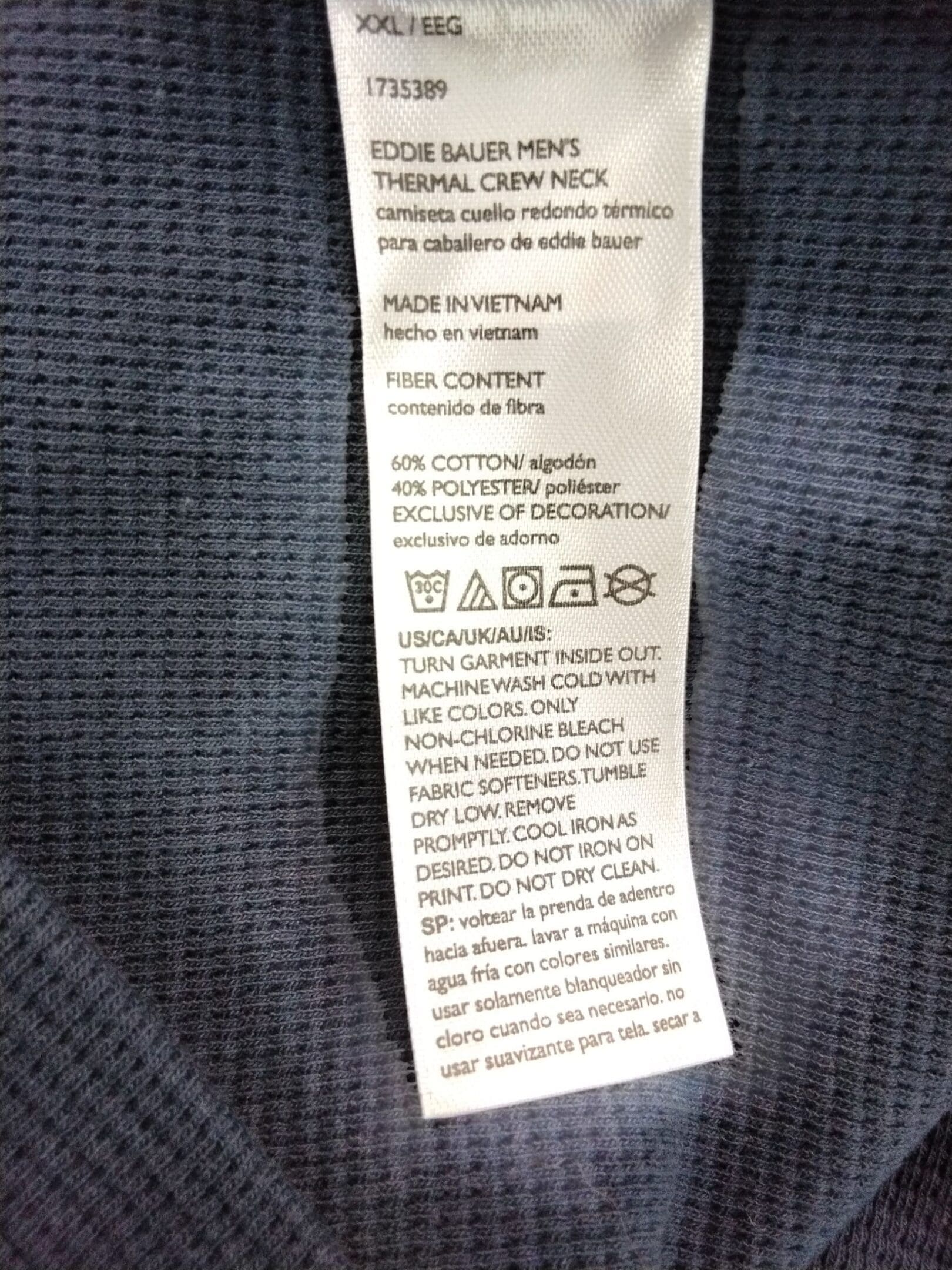 Clothing care label with washing and fabric instructions.