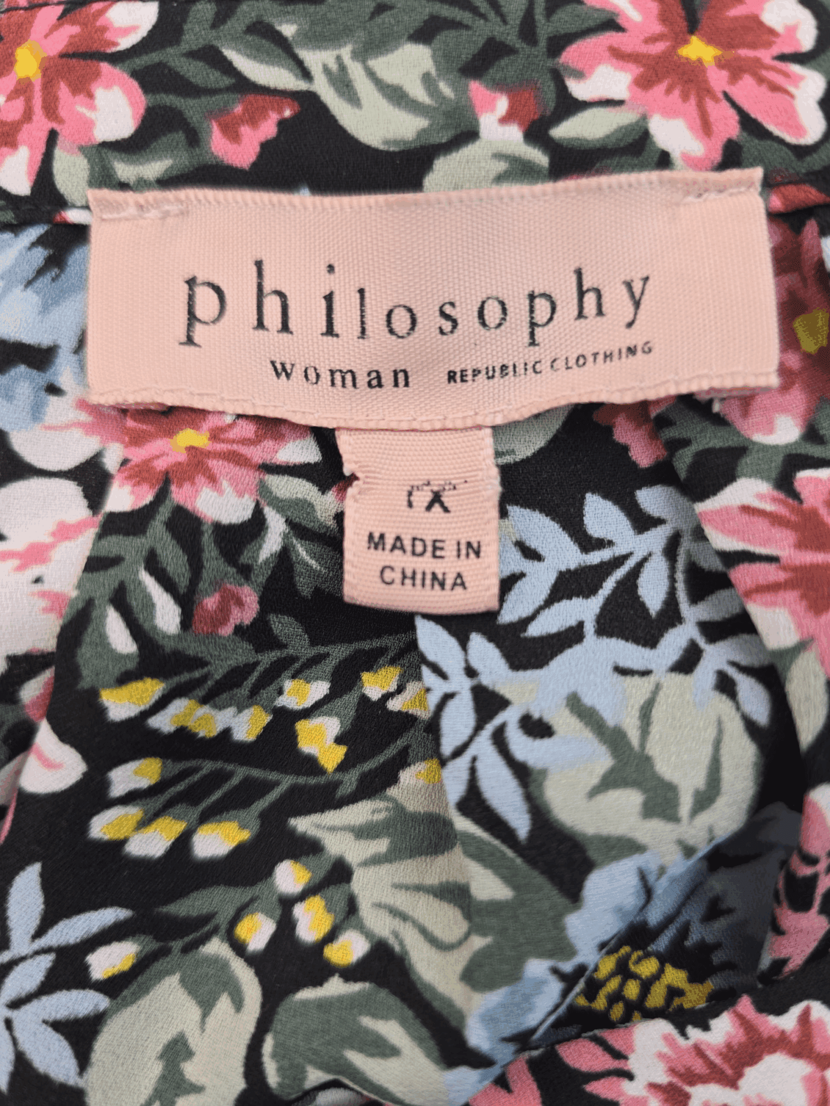 Clothing label showing 'Philosophy woman superfine' on floral fabric.