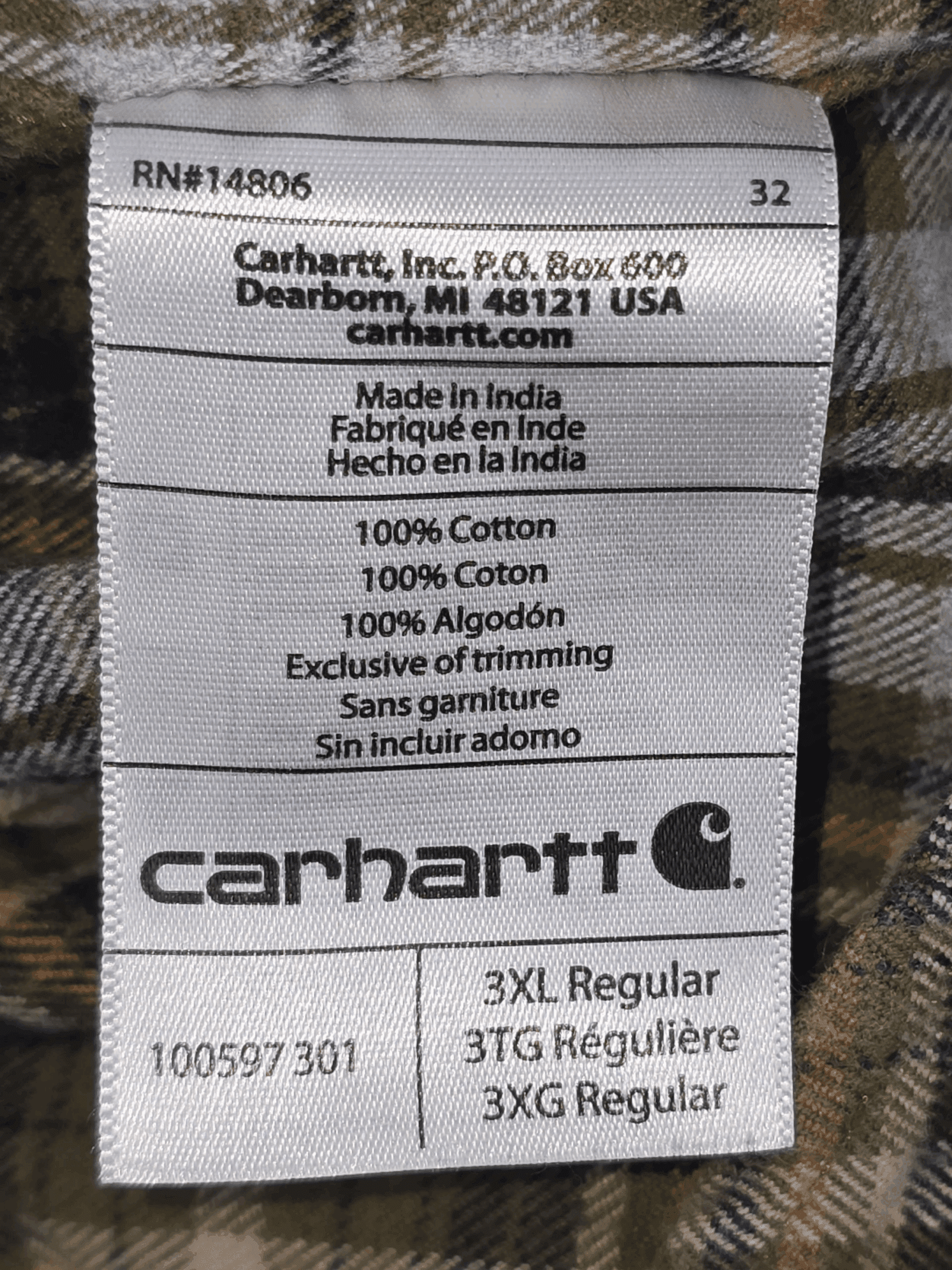 Carhartt clothing label with size and fabric details.