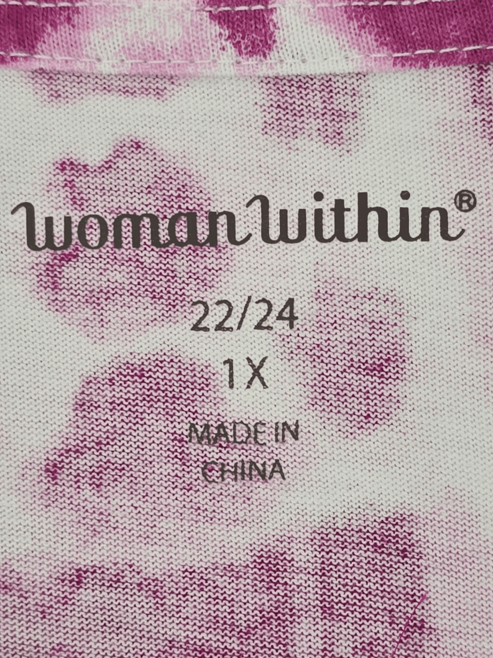 Close-up of a clothing label with brand and size information.