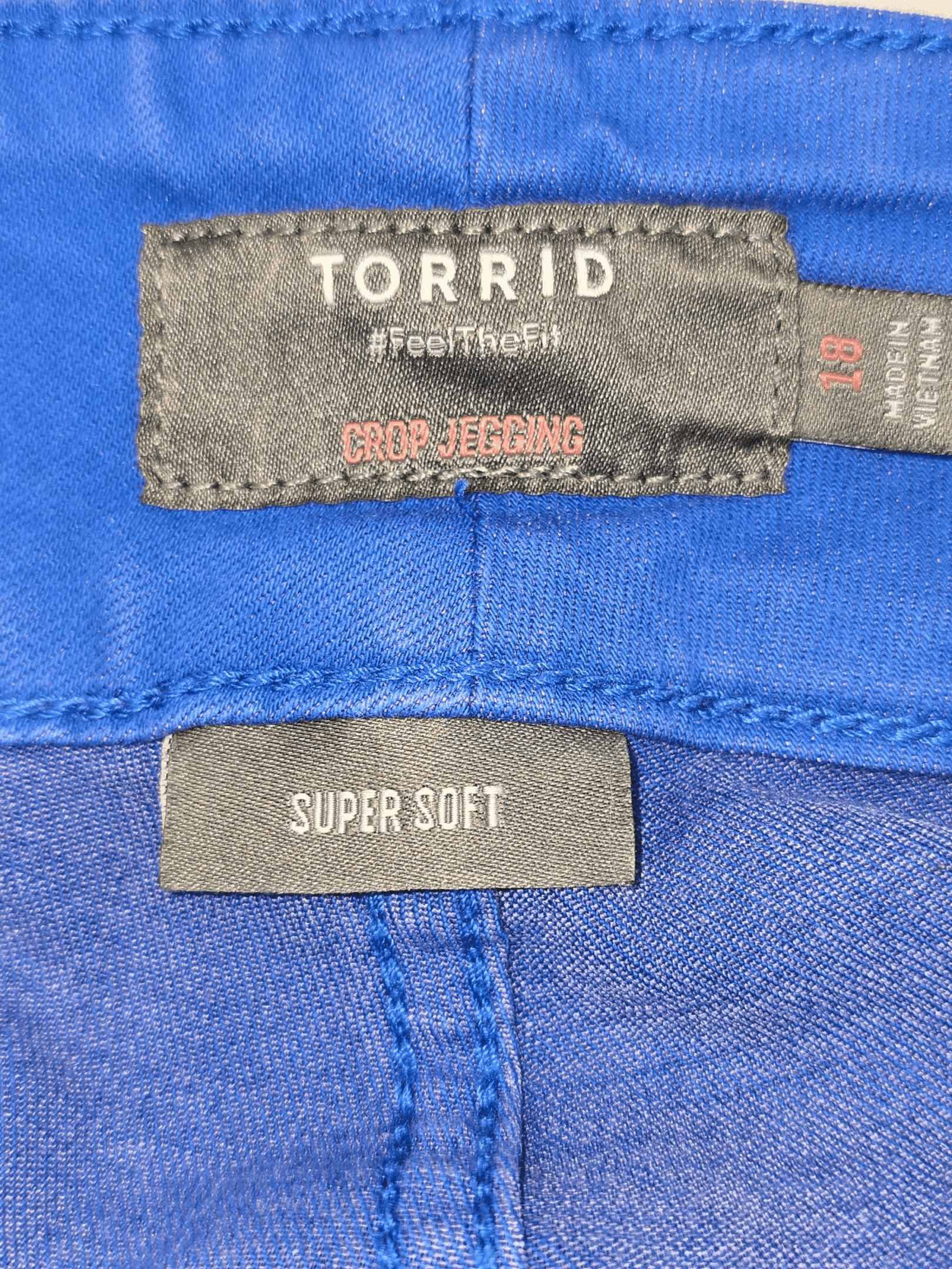 Close-up of clothing labels on a blue garment.