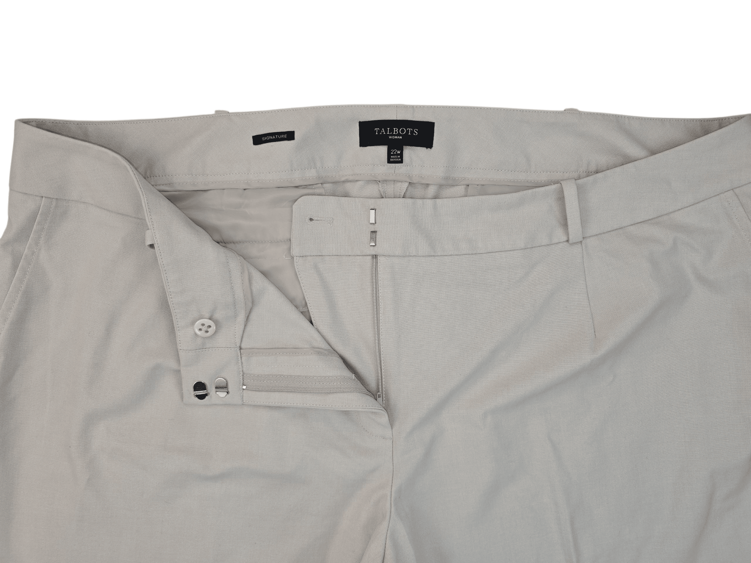 Close-up of beige pants with open zipper and button.