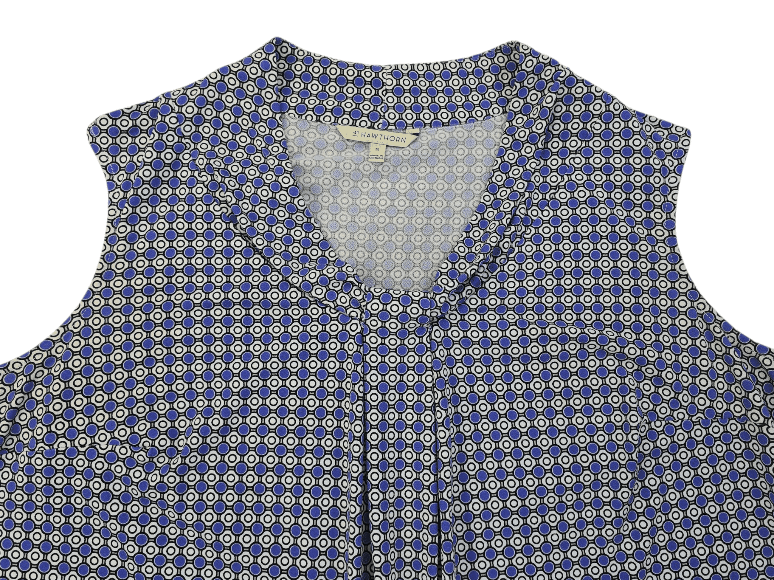 Close-up of a patterned sleeveless blouse with a pleated front.