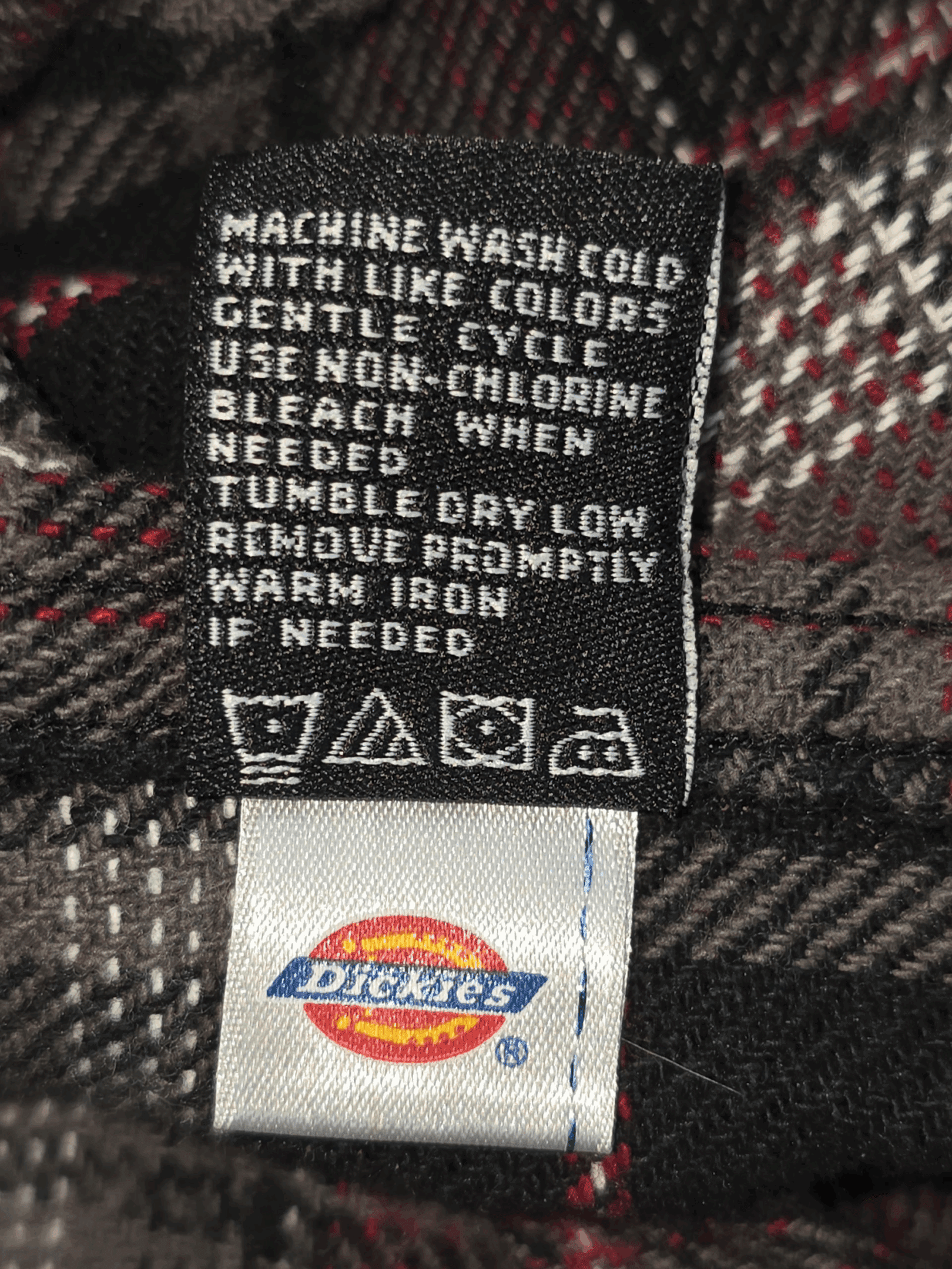 Garment care instruction tag from Dickies gray, black, and red plaid flannel shirt men’s size 2XL