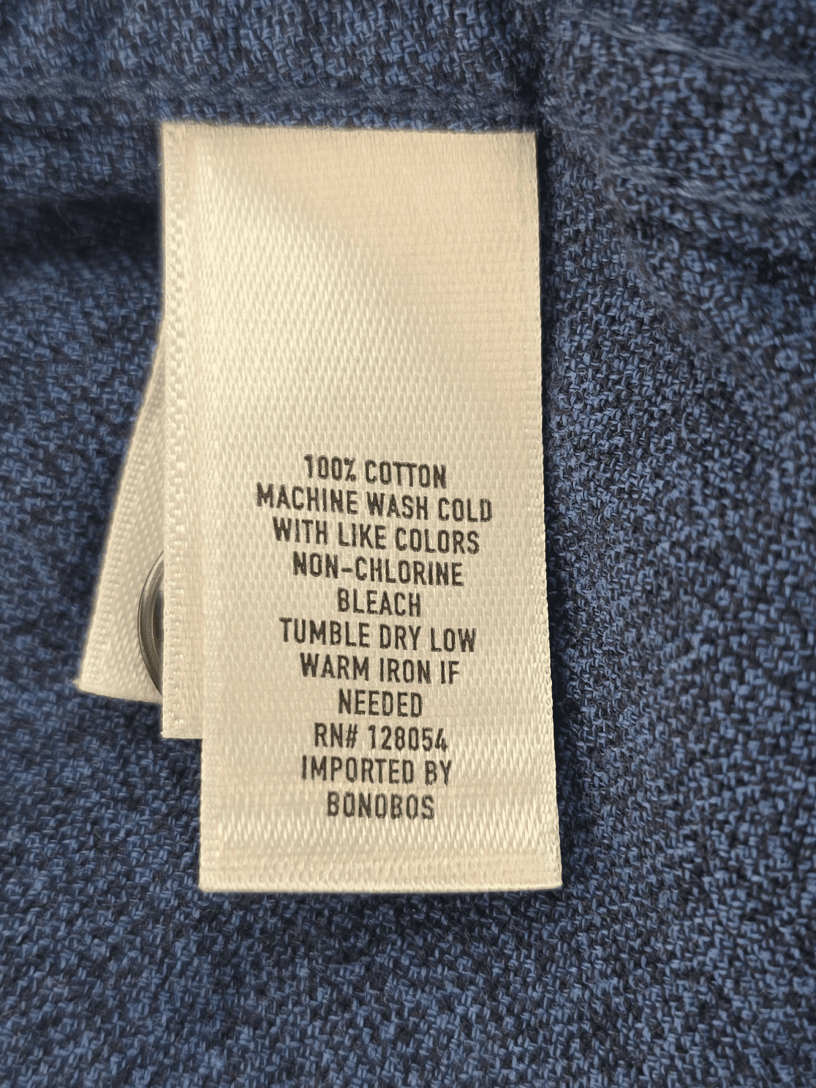 Clothing care label with washing instructions and fabric details.