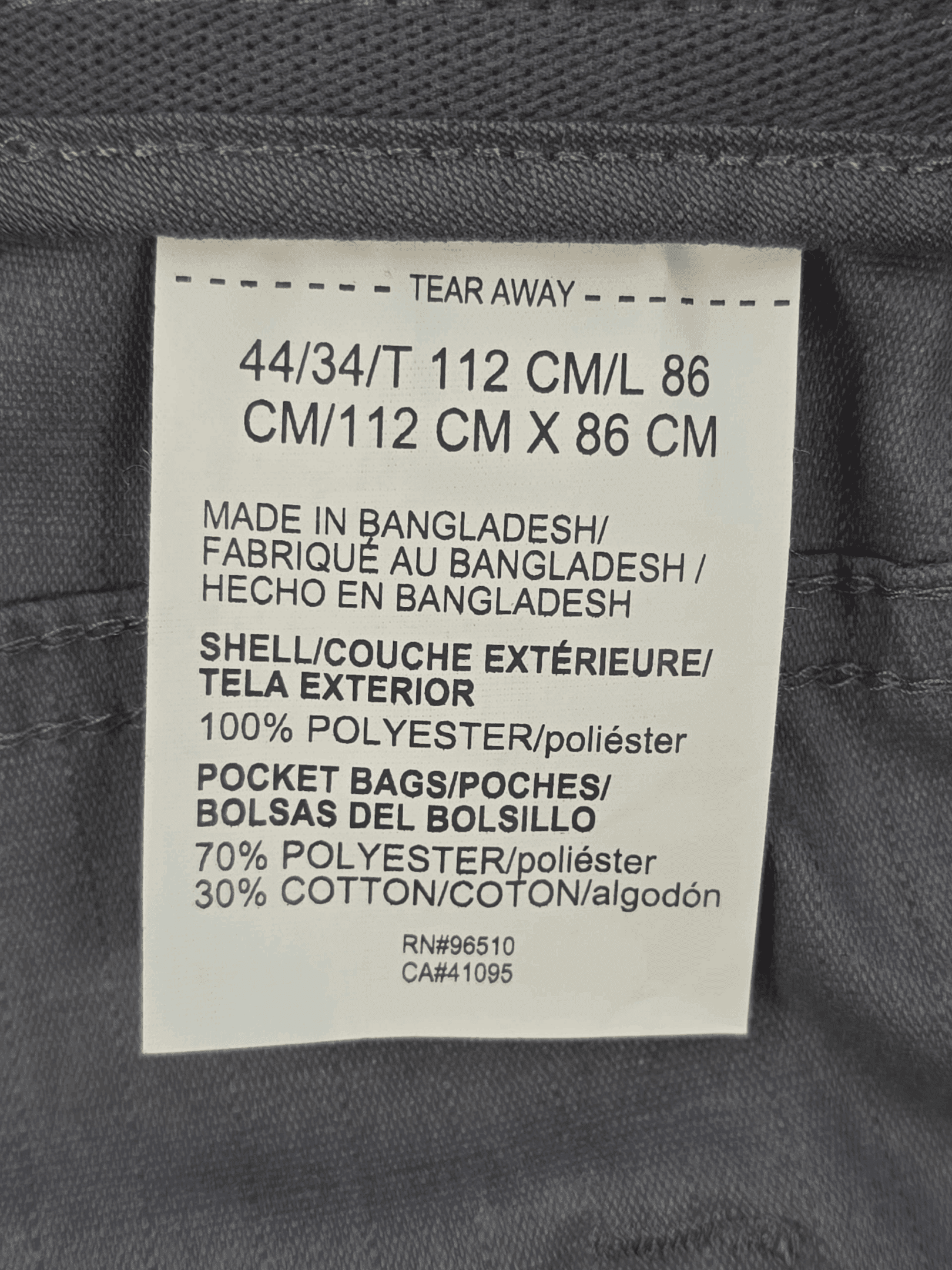 Close-up of material content and garment care tag on Under Armour men’s Big & Tall size 44 Storm Quick-Dry ripstop pants