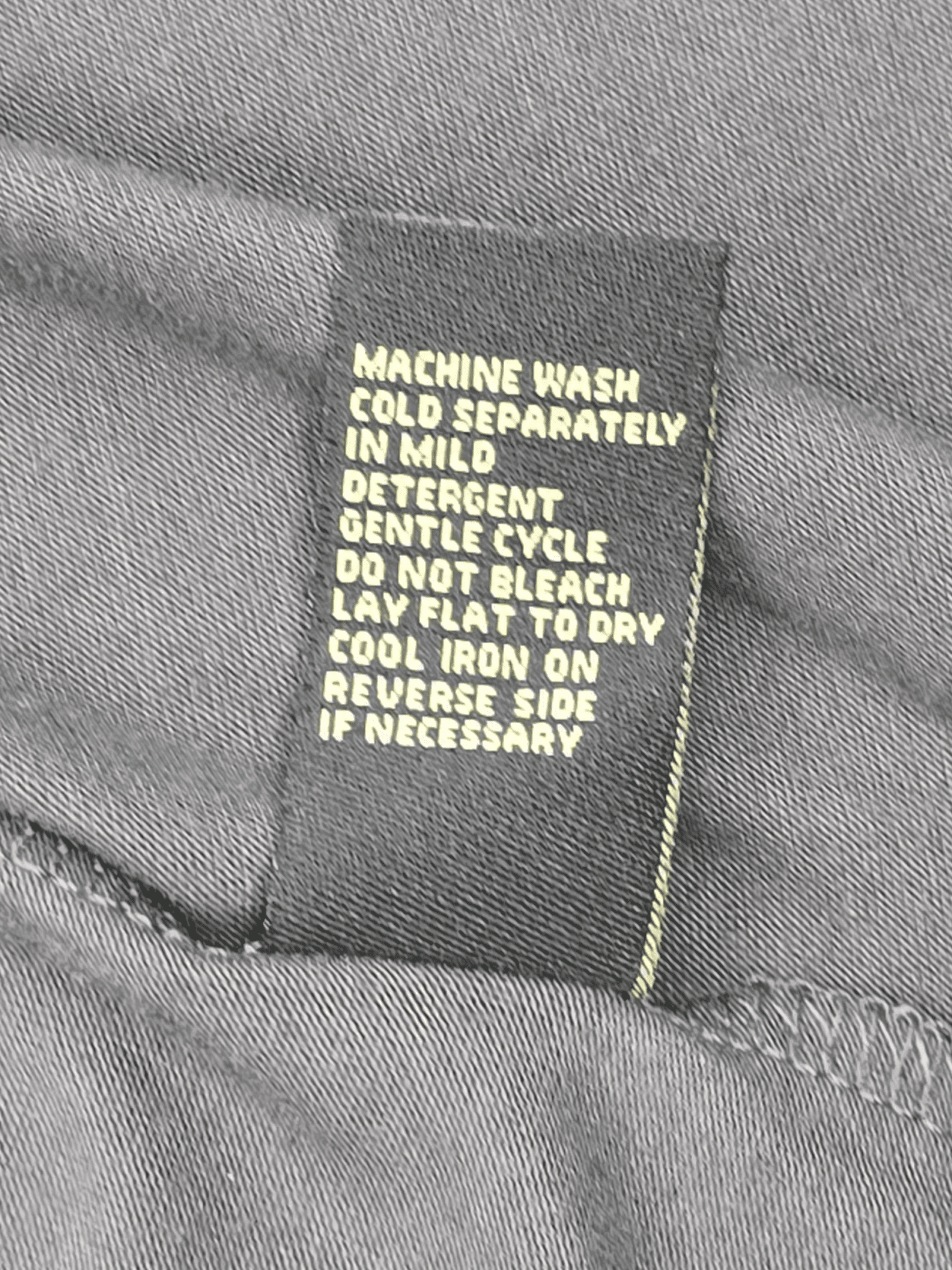 Garment care instruction tag from Diane Gilman gray layered look pullover top women’s plus size 3X.