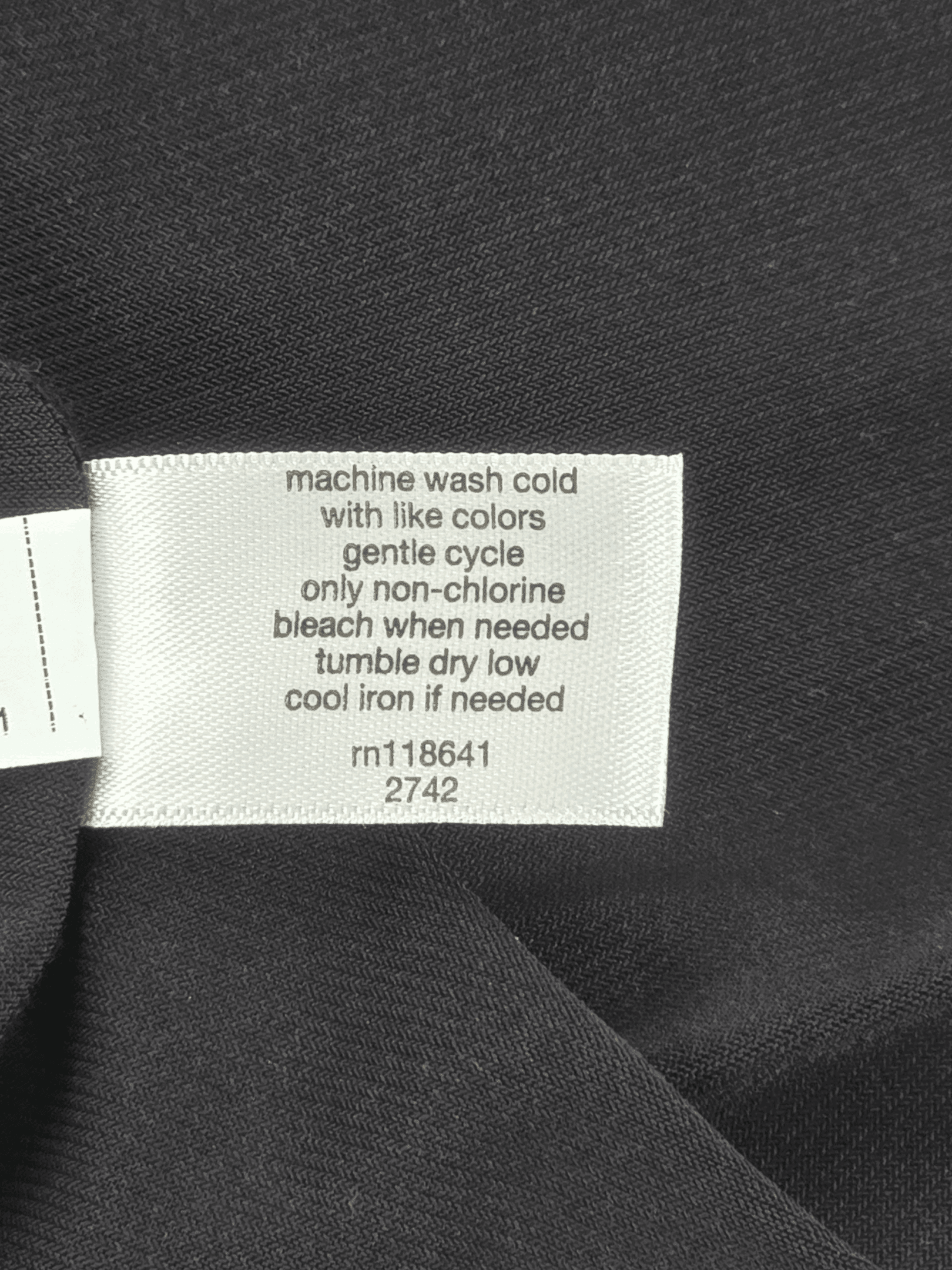 Clothing tag with care instructions and color warnings.