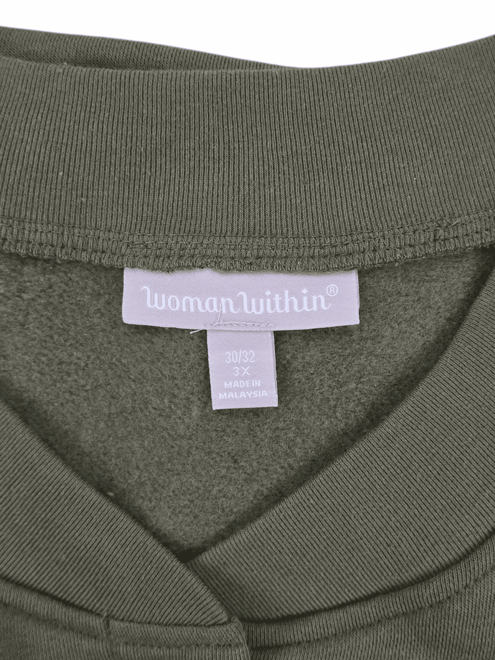 Close-up of a clothing label on an olive green fabric.