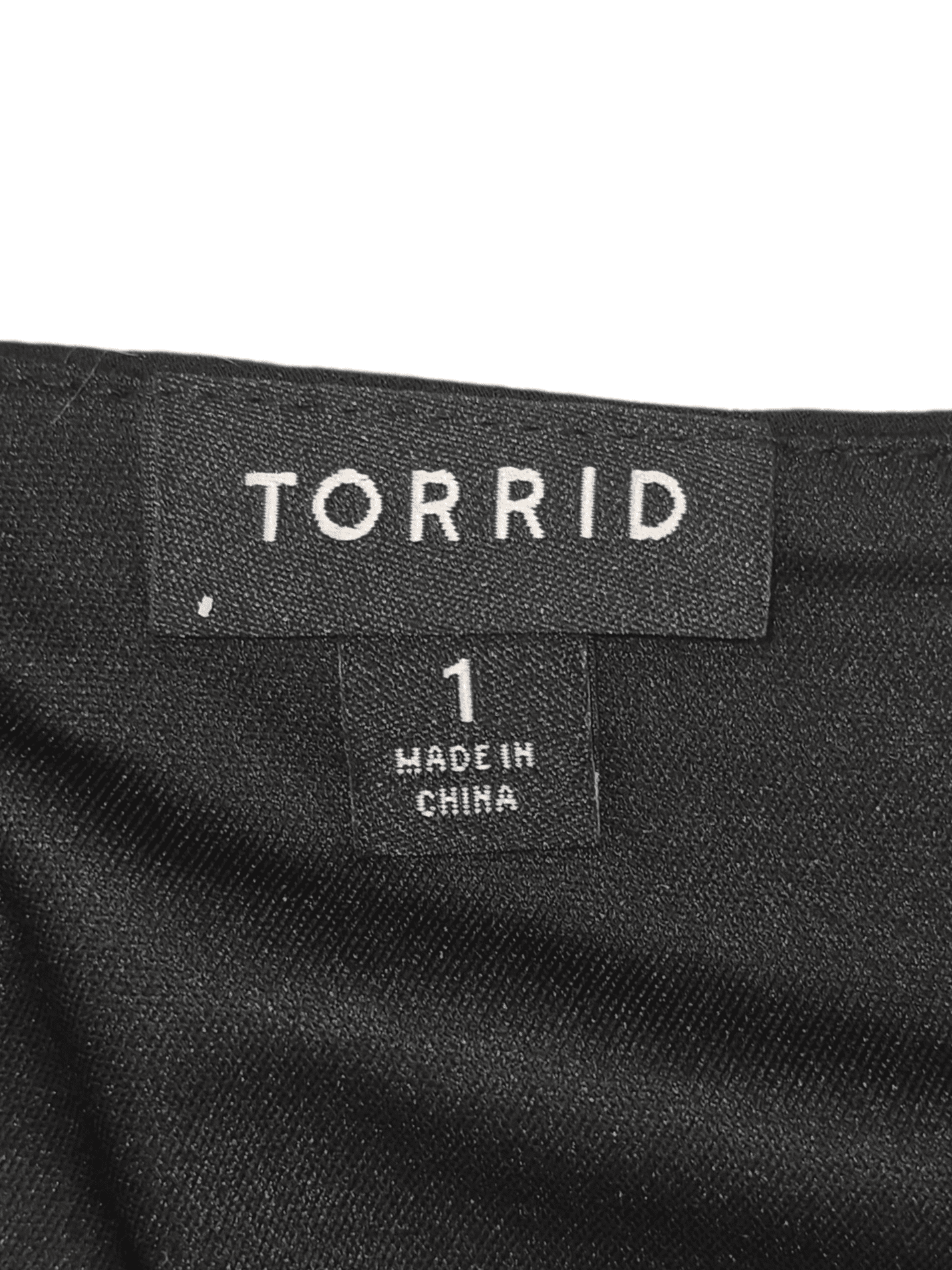 Clothing label showing 'TORRID' and size 1, made in China.