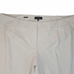 Close-up of beige pants with a black button and zipper.