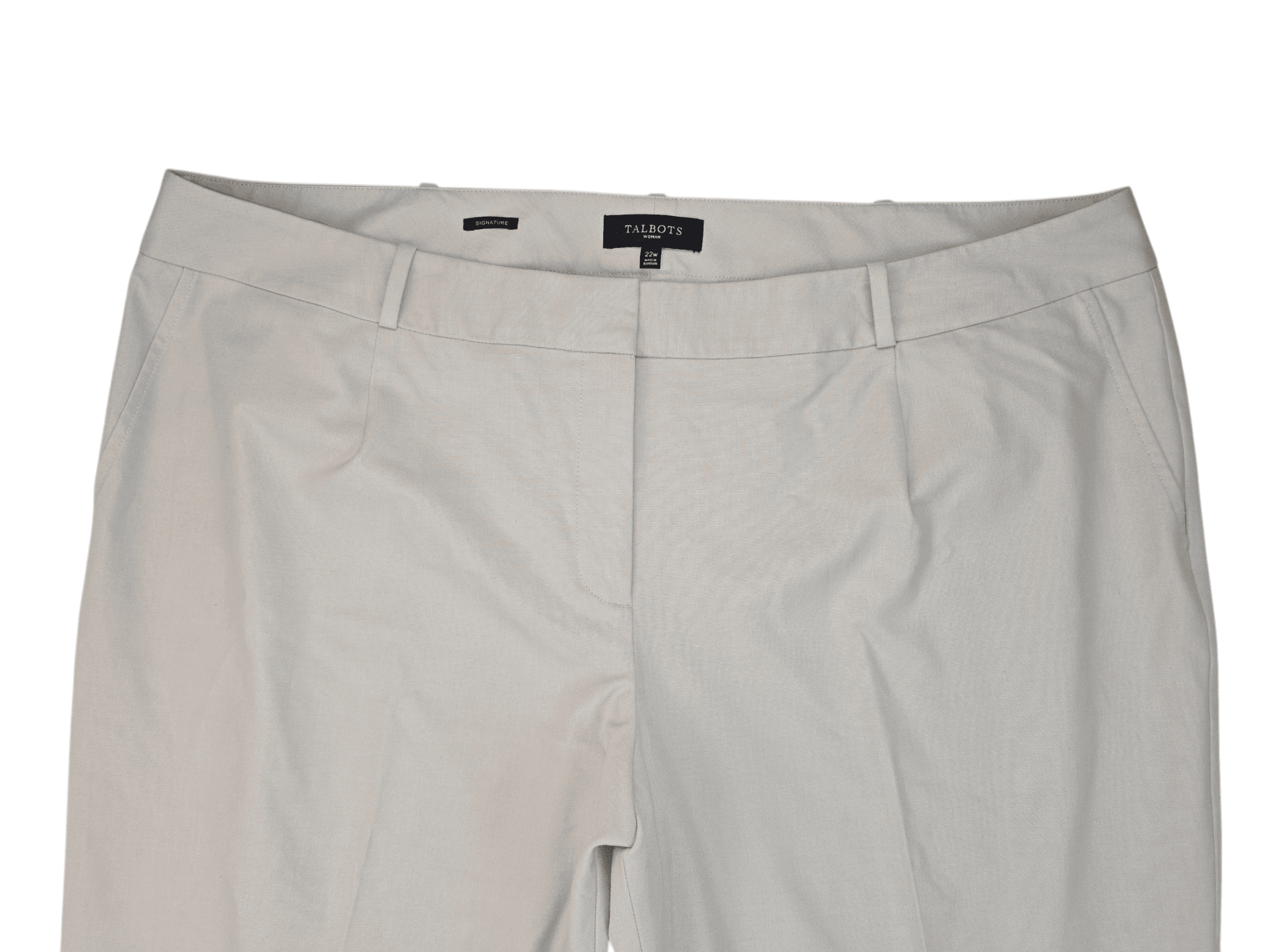 Close-up of beige pants with a black button and zipper.
