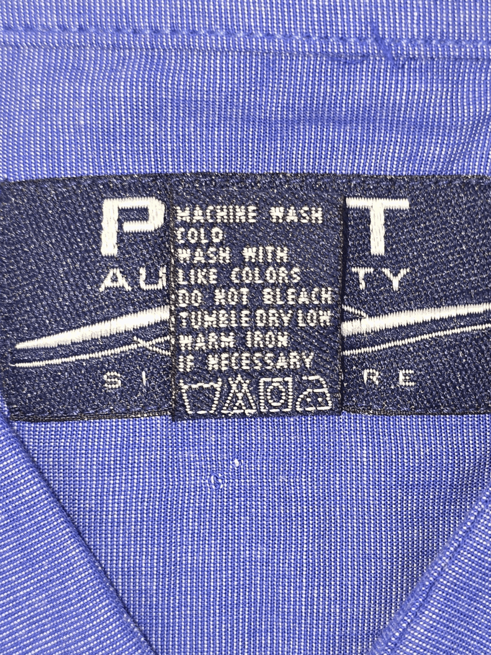 Clothing care label with washing instructions and fabric content.