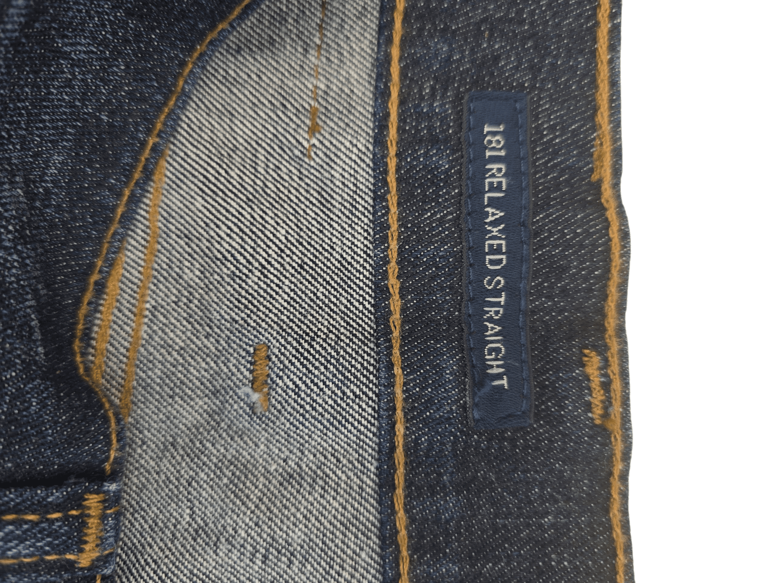 Close-up of denim fabric with 'Relaxed Straight' label.