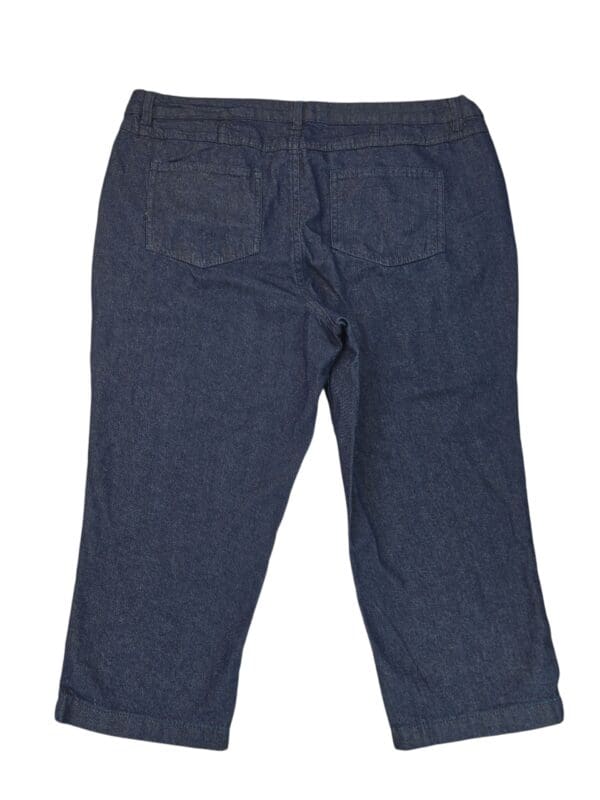 Dark blue denim jeans laid flat, showing the back side with pockets.