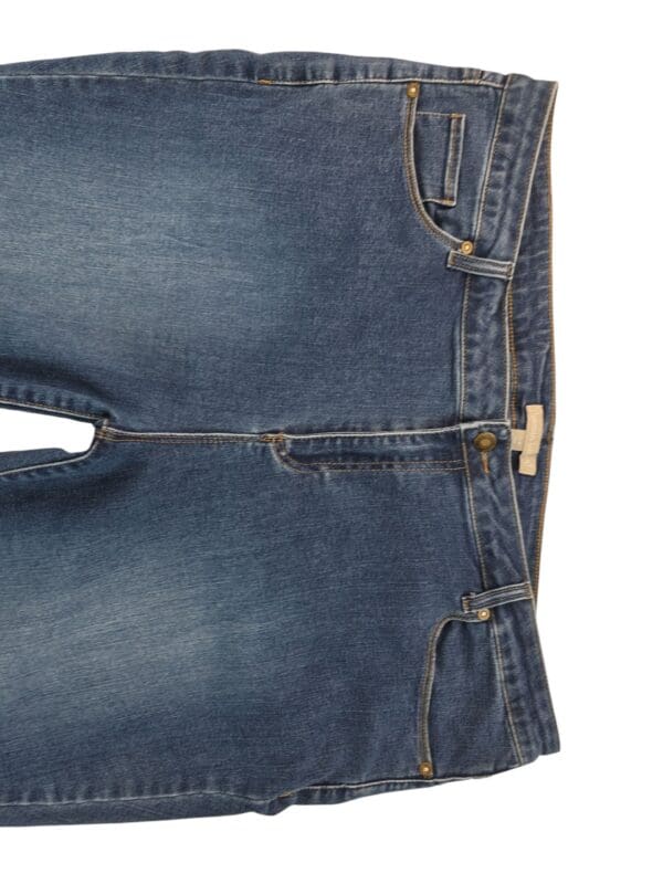 A pair of blue denim jeans laid flat, showing front view and pockets.