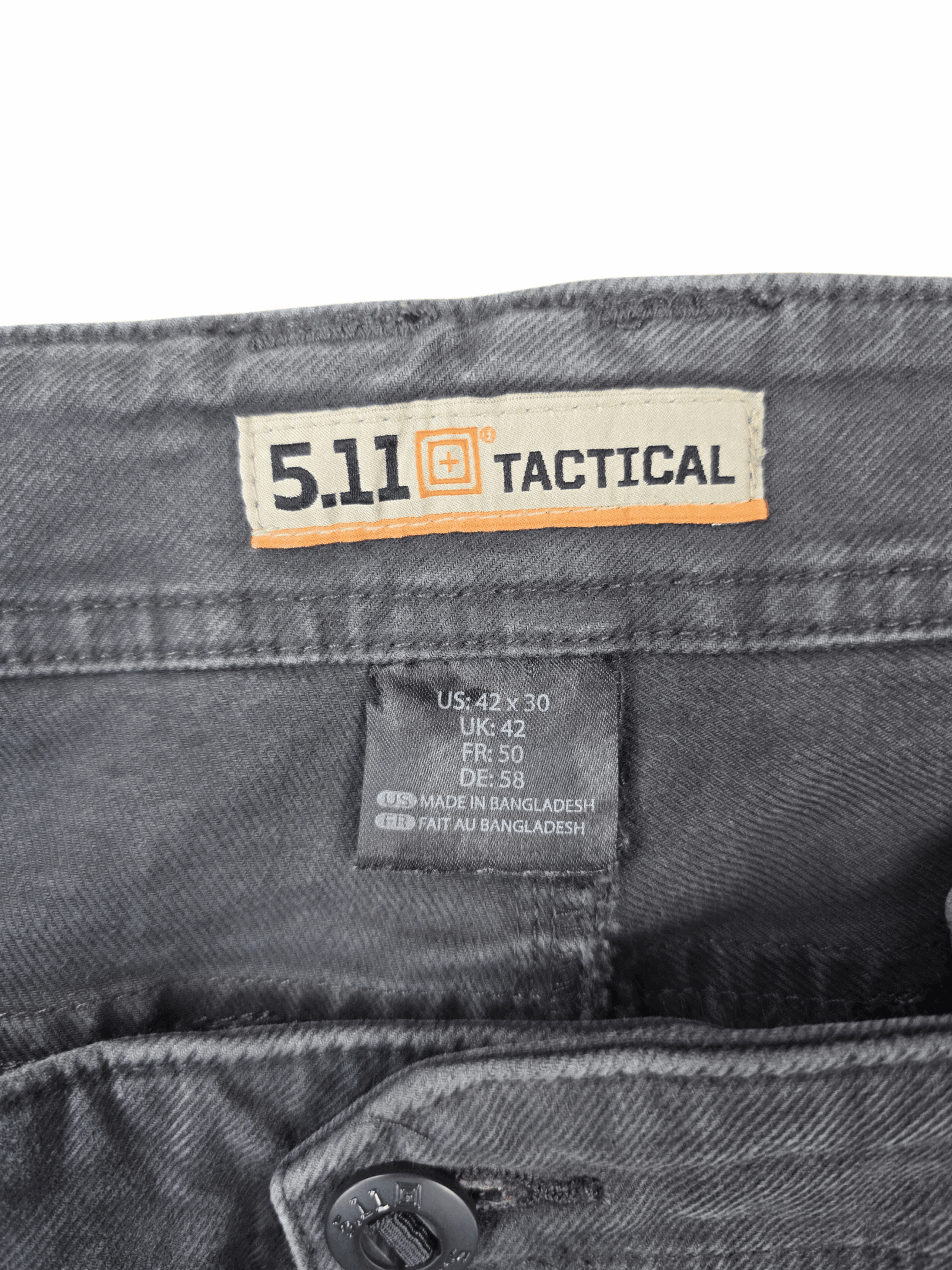 Close-up of 5.11 Tactical brand and 42x30 size tag on gray twill stretch pants