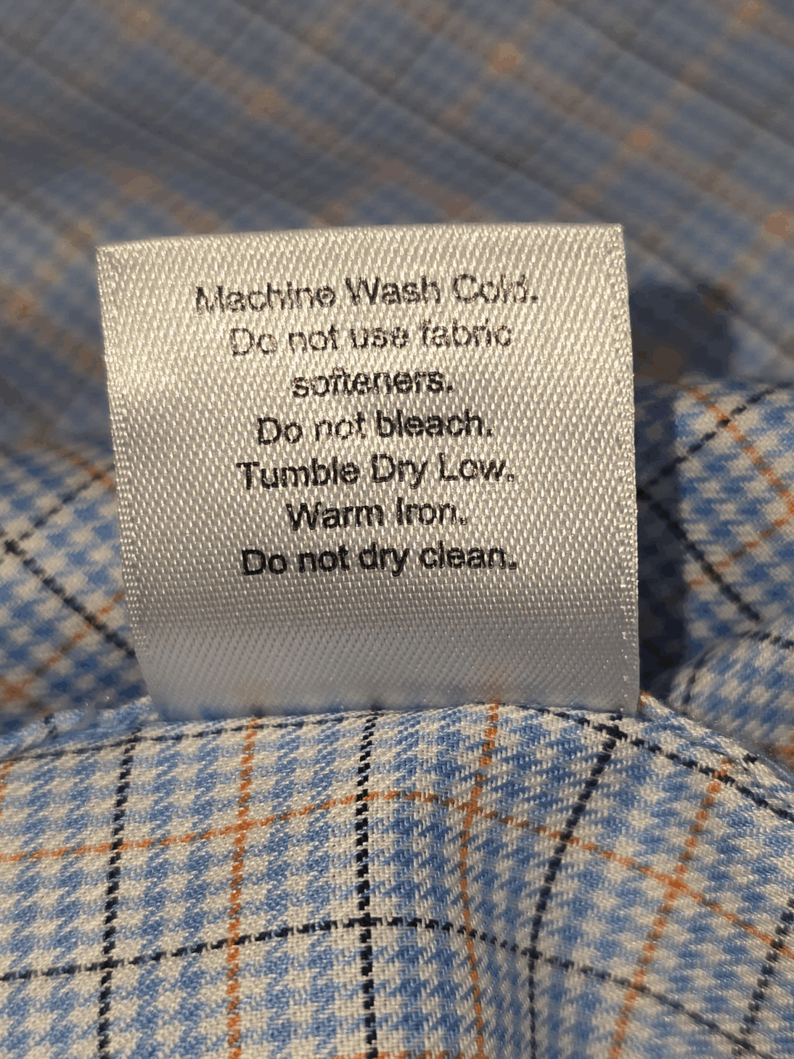 Fabric content tag displaying 100% cotton and washing instructions