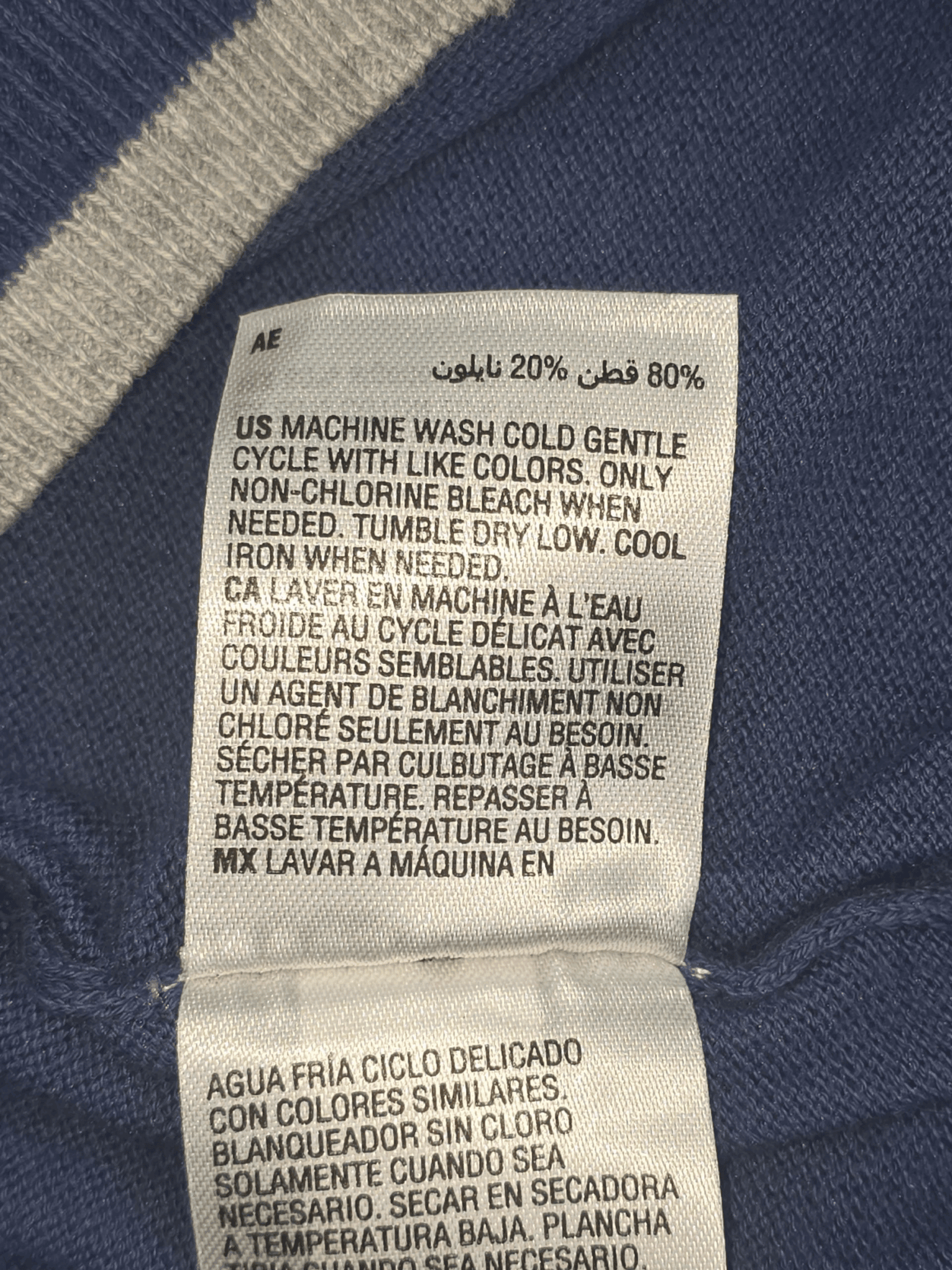 Close-up of material content and garment care tag on NWT ALFANI men’s size XXL navy blue cotton blend crew neck sweater