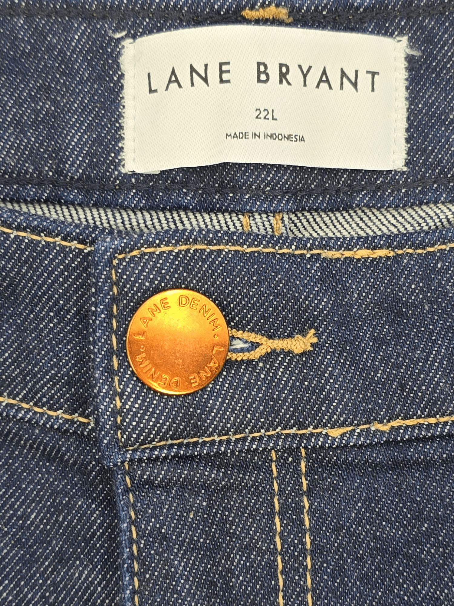 Close-up of Lane Bryant brand and 22 size tag on cropped jeans with plaid cuff