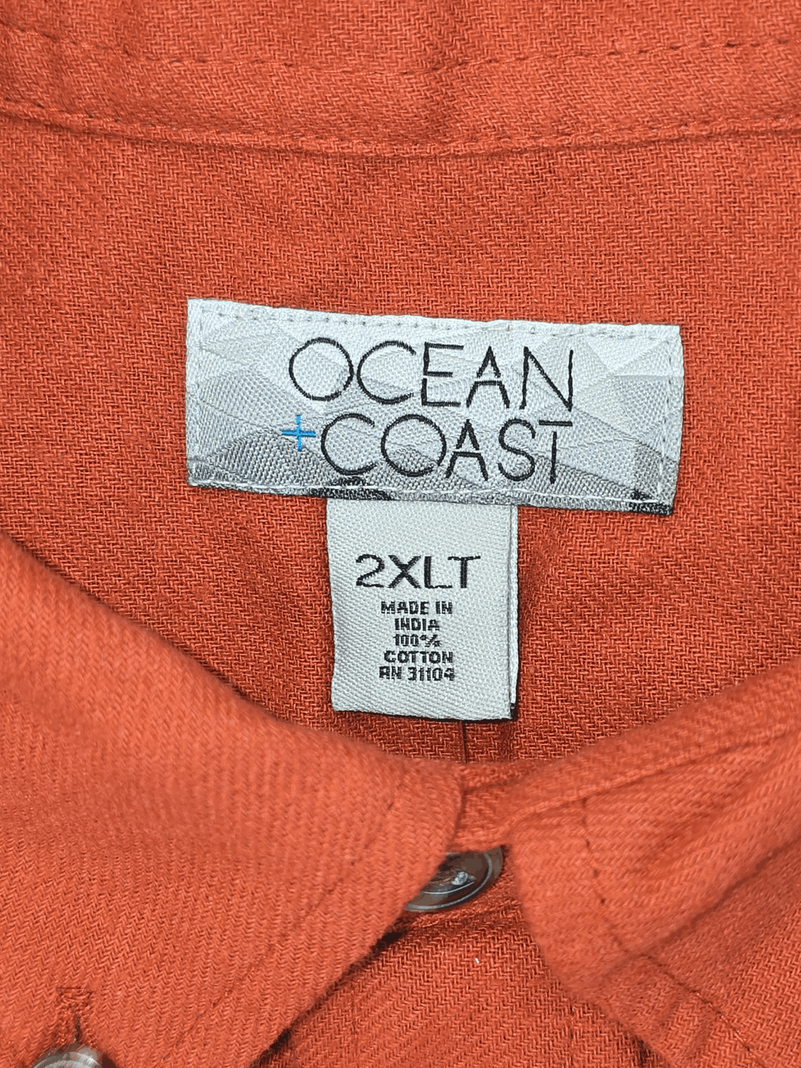 Close-up of Ocean & Coast brand and 2XLT size tag on orange button-up shirt