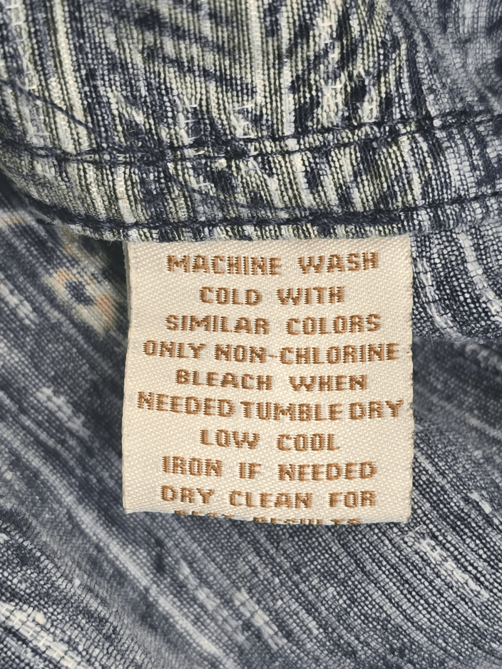 Close-up of material content and garment care tag on Caribbean men’s size 4XB pure silk Hawaiian shirt with tropical print