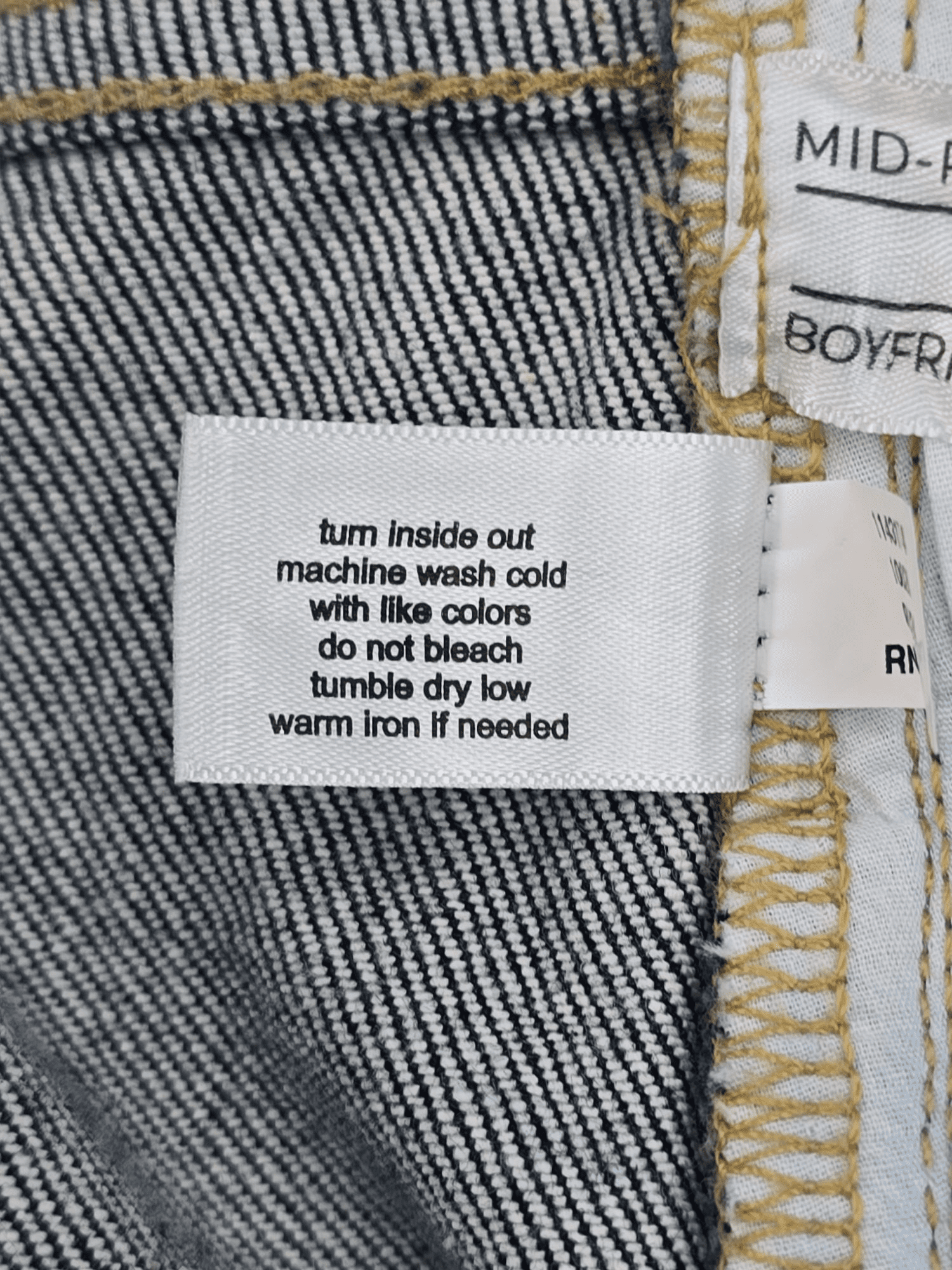 Close-up of material content and garment care tag on Lane Bryant women’s size 22 cropped jeans with plaid cuff