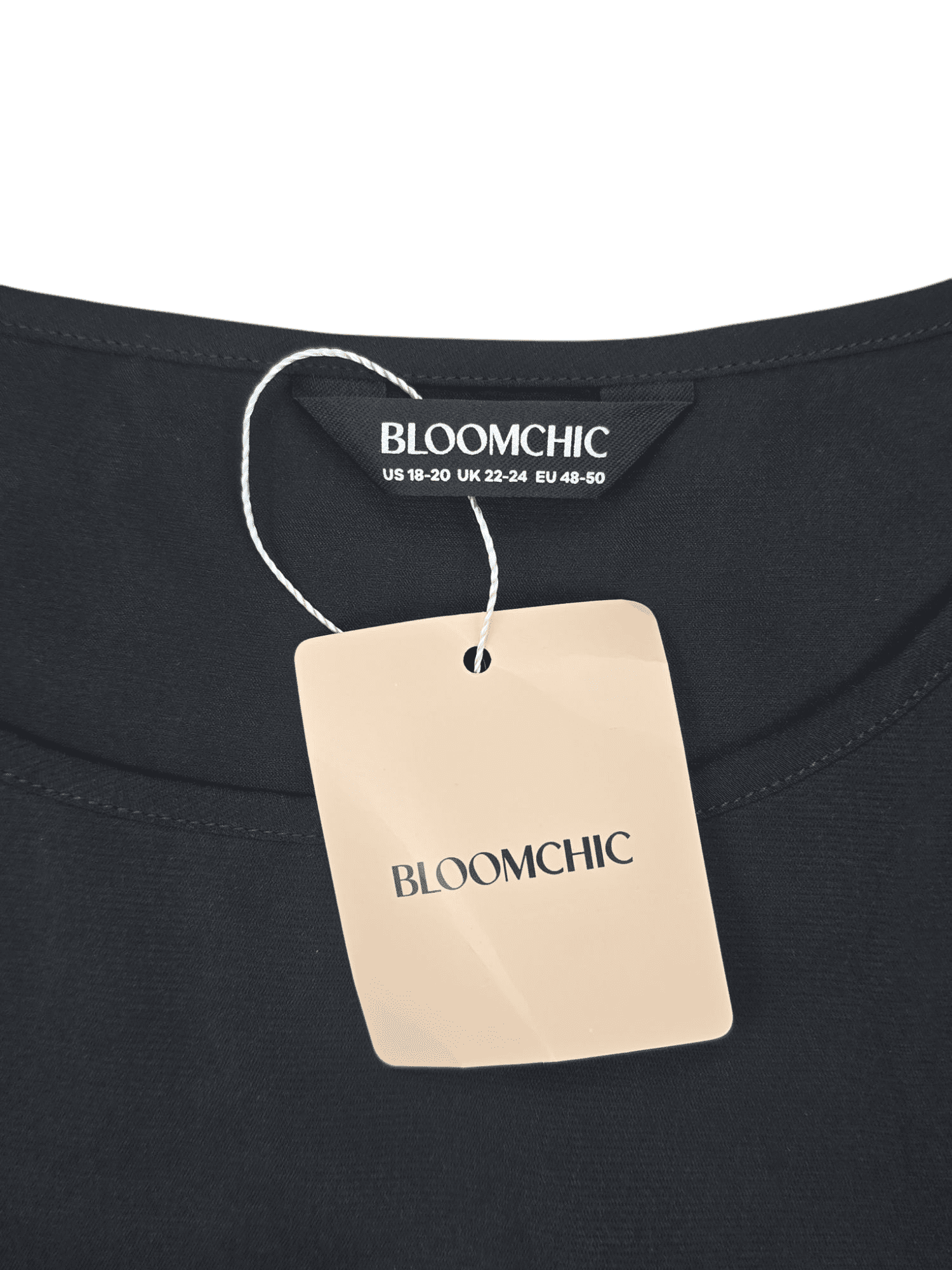 Close-up of BloomChic brand and size 18/20 tag with store tag on black and white layered-look pullover top