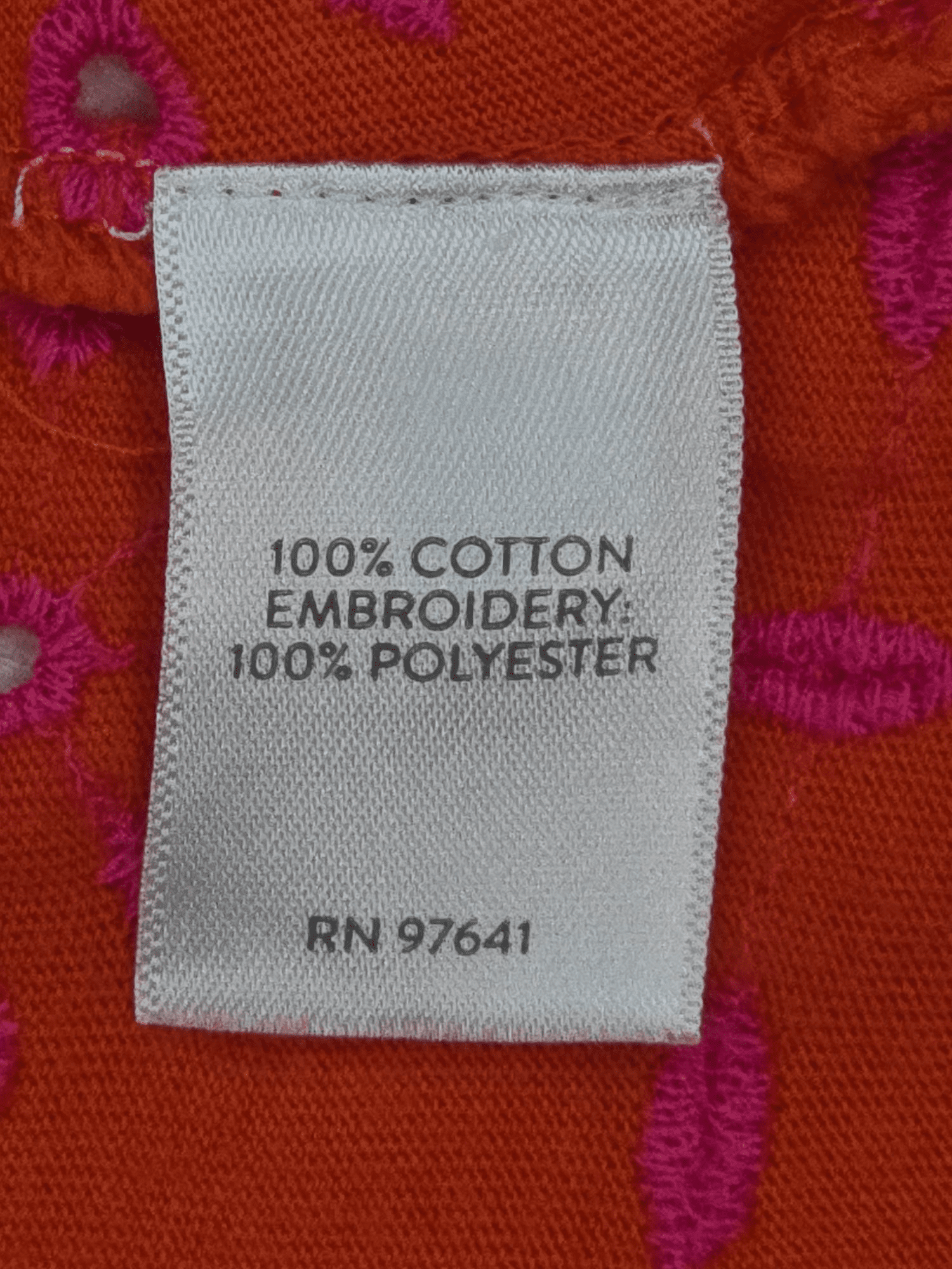 Close-up of material content and garment care tag on J. Jill women’s size 2X orange cotton eyelet V-neck pullover top