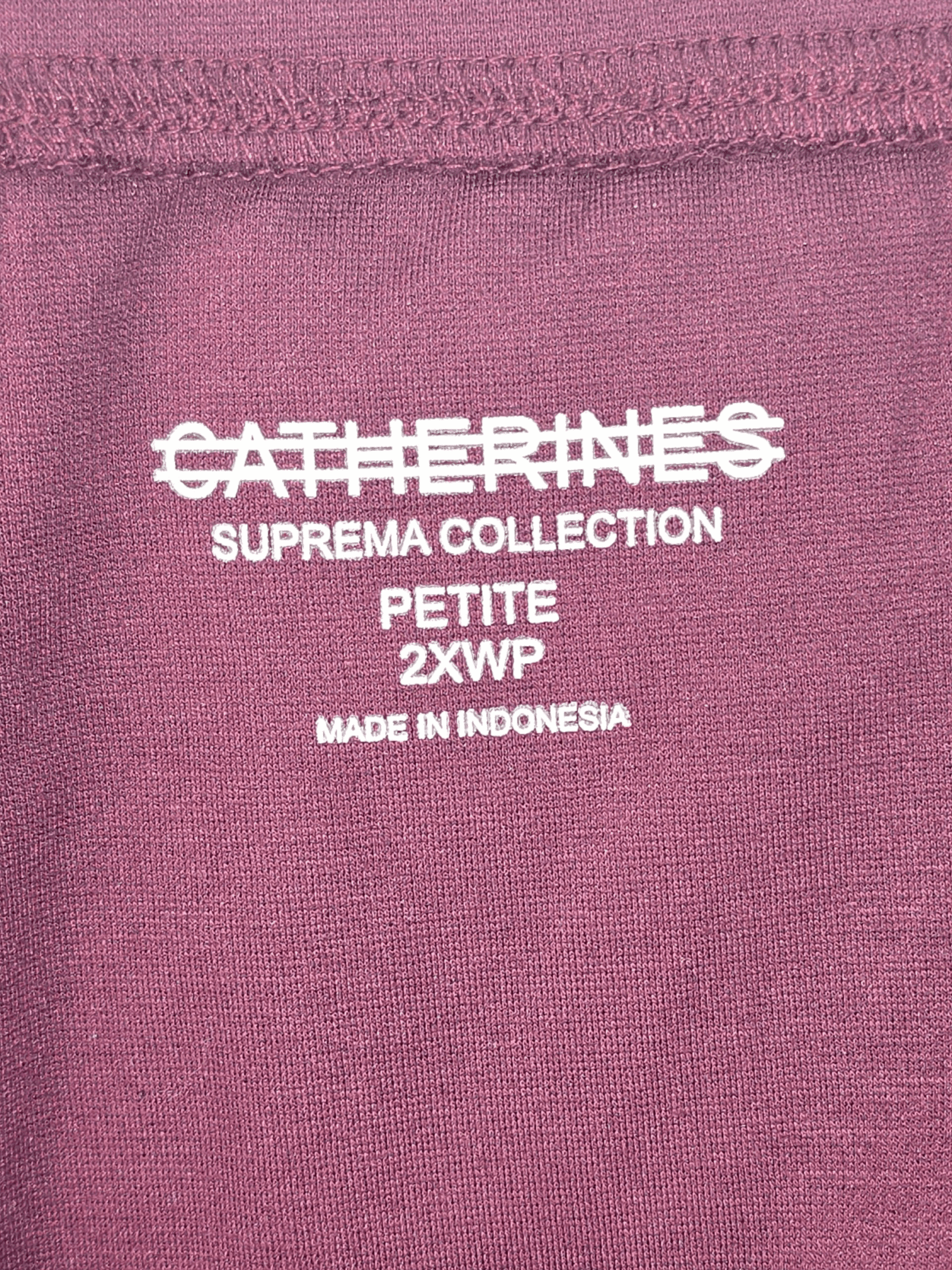 Close-up of Catherine’s Suprema Collection brand and 2X petite size tag on wine pull-on capri pants