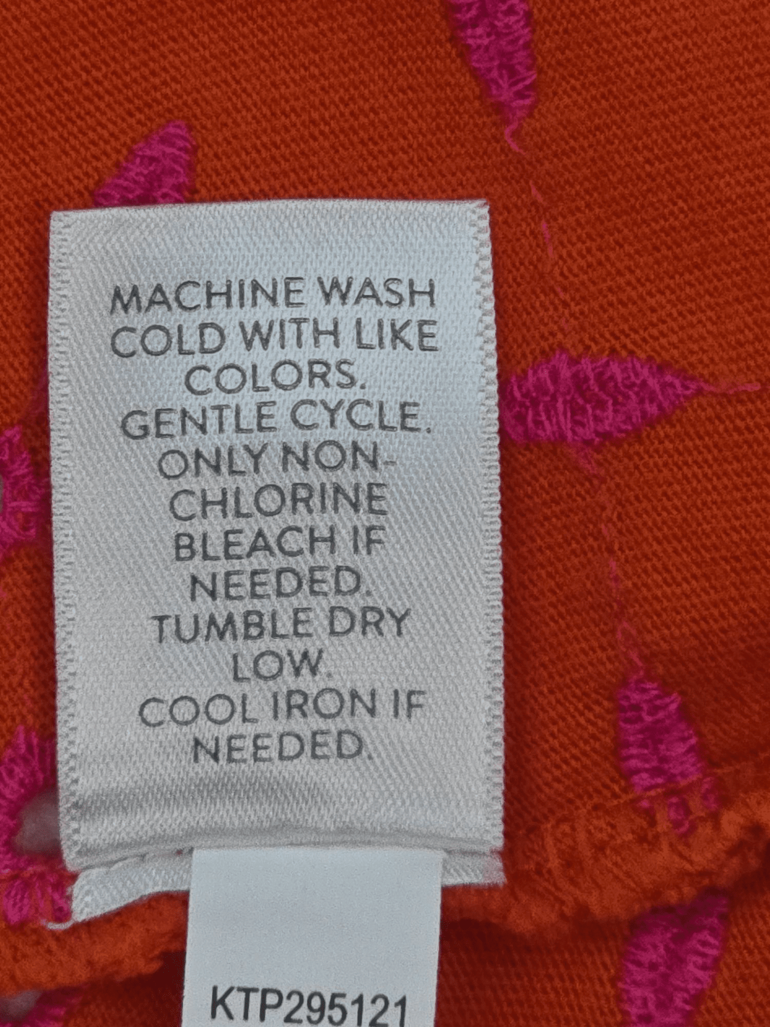 Close-up of material content and garment care tag on J. Jill women’s size 2X orange cotton eyelet V-neck pullover top
