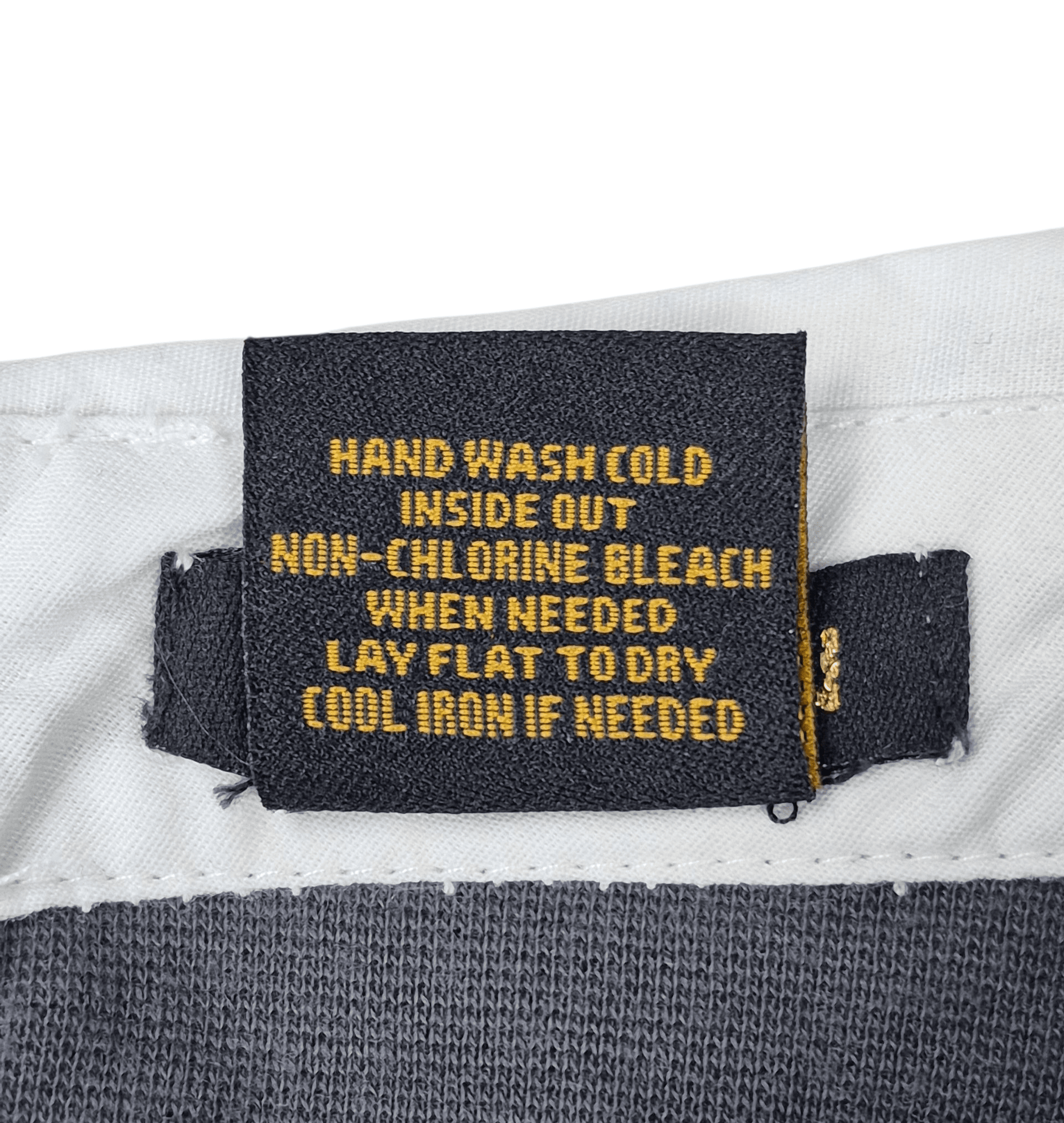 Close-up of material content and garment care tag on IMAN women’s size 3X gray knit pullover faux layered top