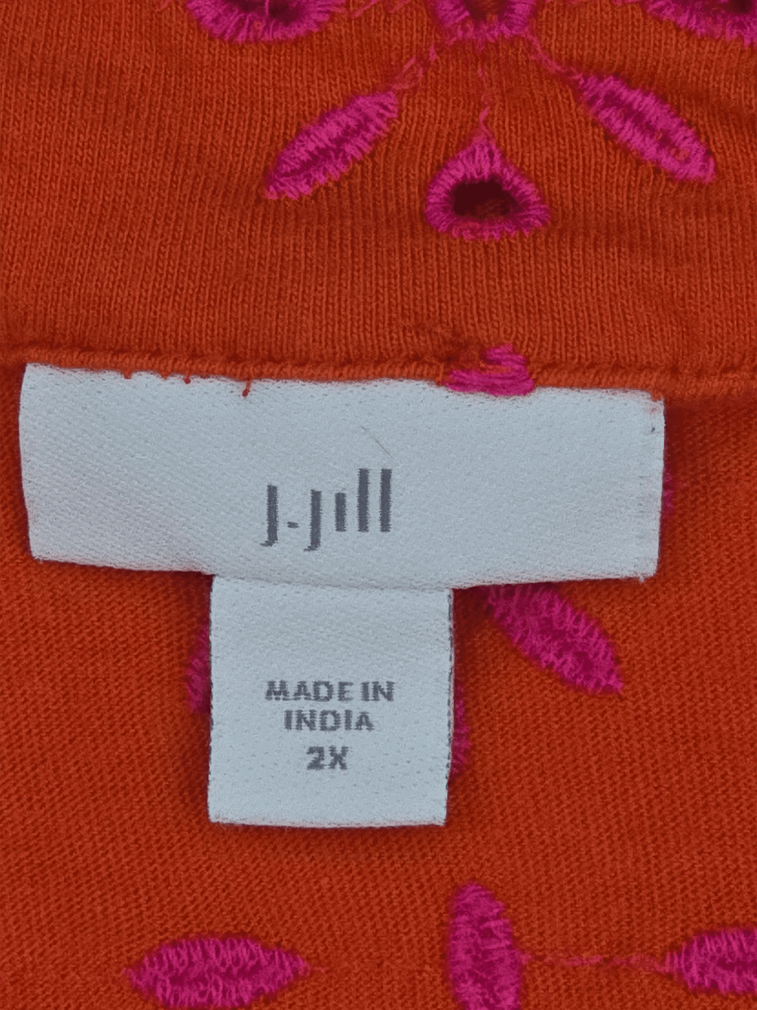 Close-up of J. Jill brand and 2X size tag on orange cotton eyelet V-neck pullover top