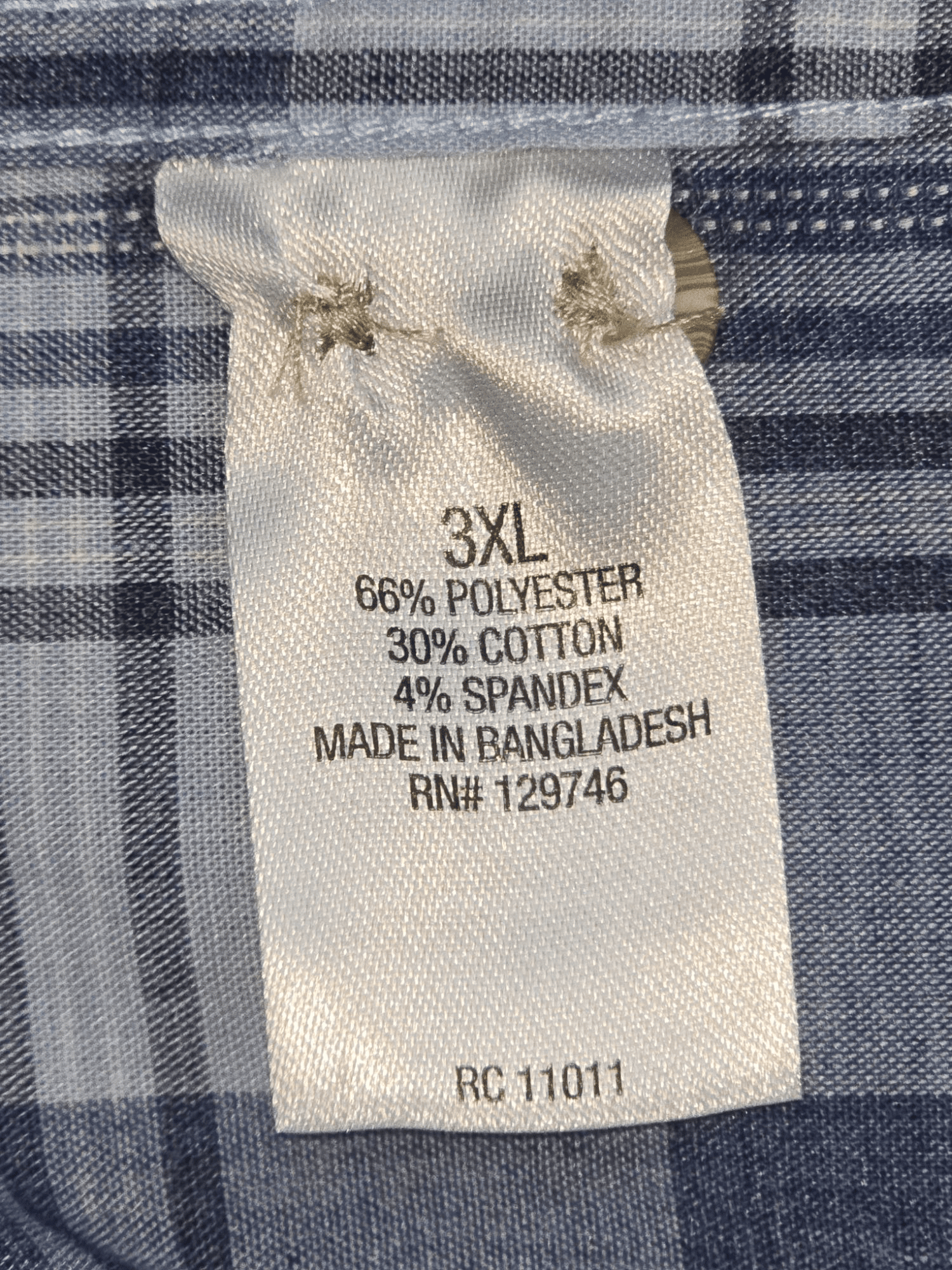Close-up of material content and garment care tag on Ridgecut men’s size 3XL blue checked button-up shirt