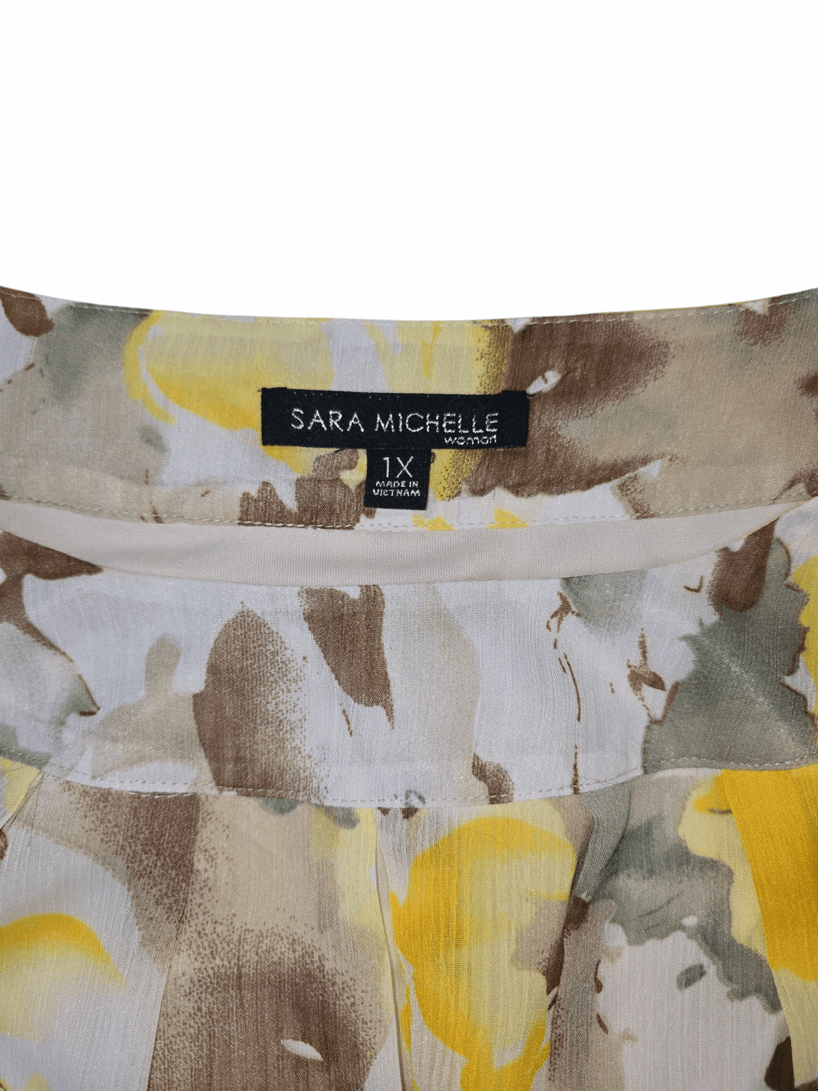 Close-up of Sarah Michelle Woman brand and 1X size tag on floral chiffon pullover top