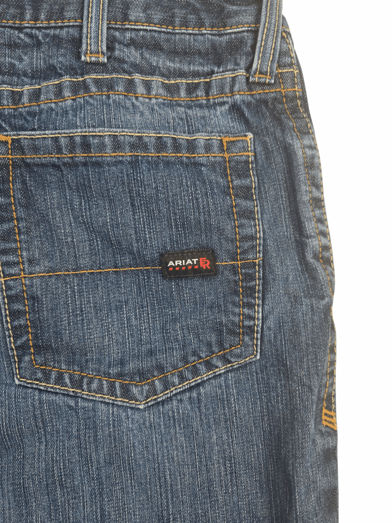 Close-up of Ariat leather brand patch on back waistband of M4 FR low-rise bootcut jeans