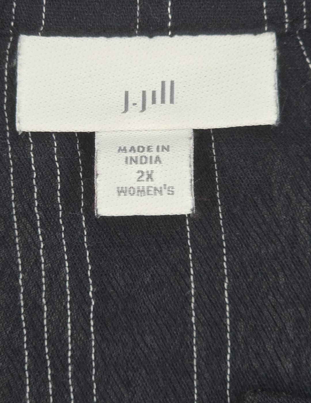 Close-up of Michael Kors brand and 2X size tag on navy blue gold-zip shirt