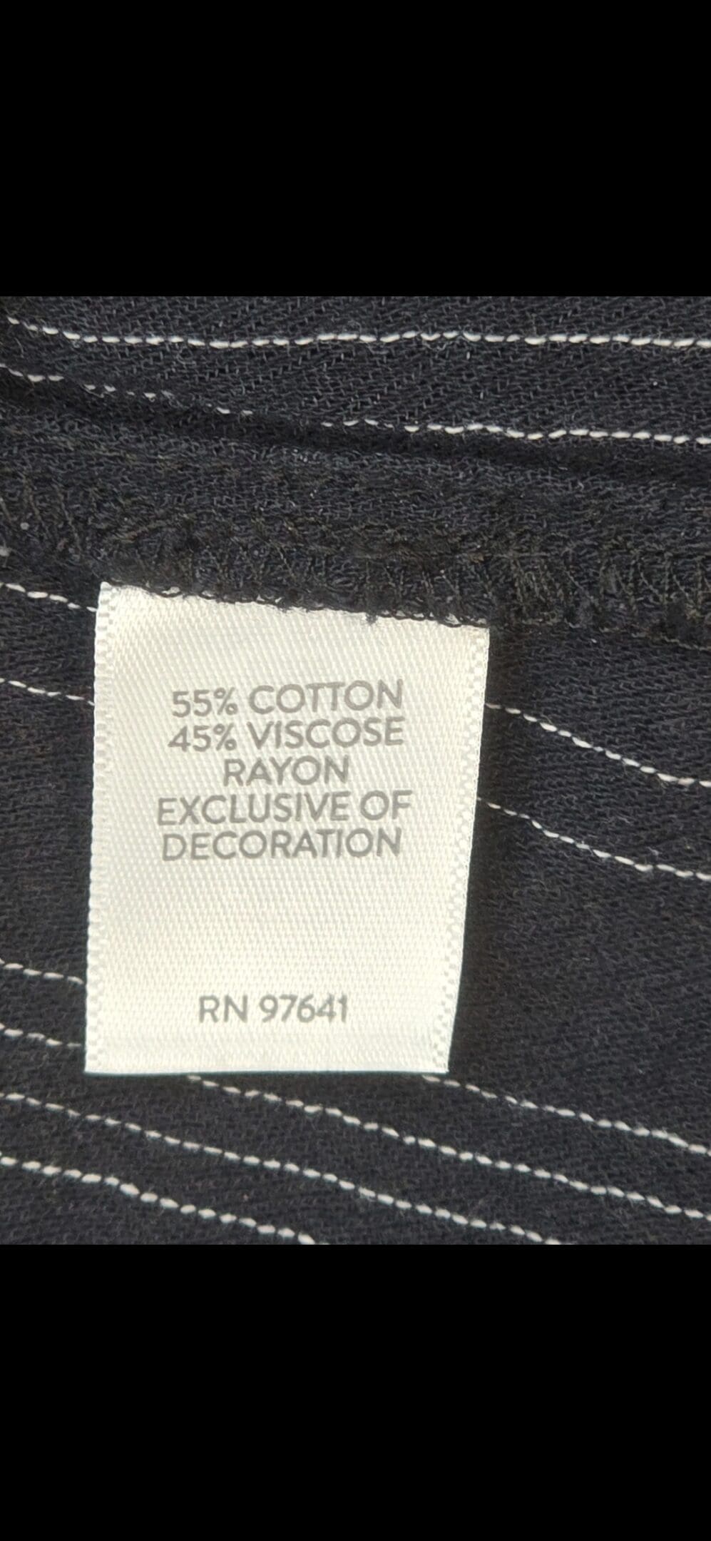 Close-up of material content and garment care tag on Michael Kors women’s size 2X navy blue gold-zip shirt