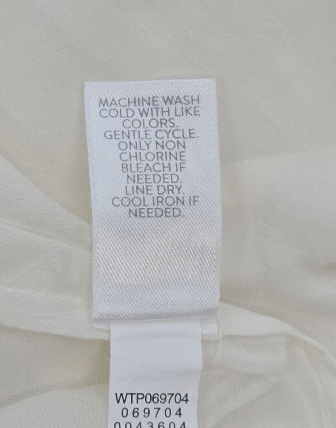 Close-up of material content and garment care tag on J. Jill women’s size 2X ivory embroidered rayon top