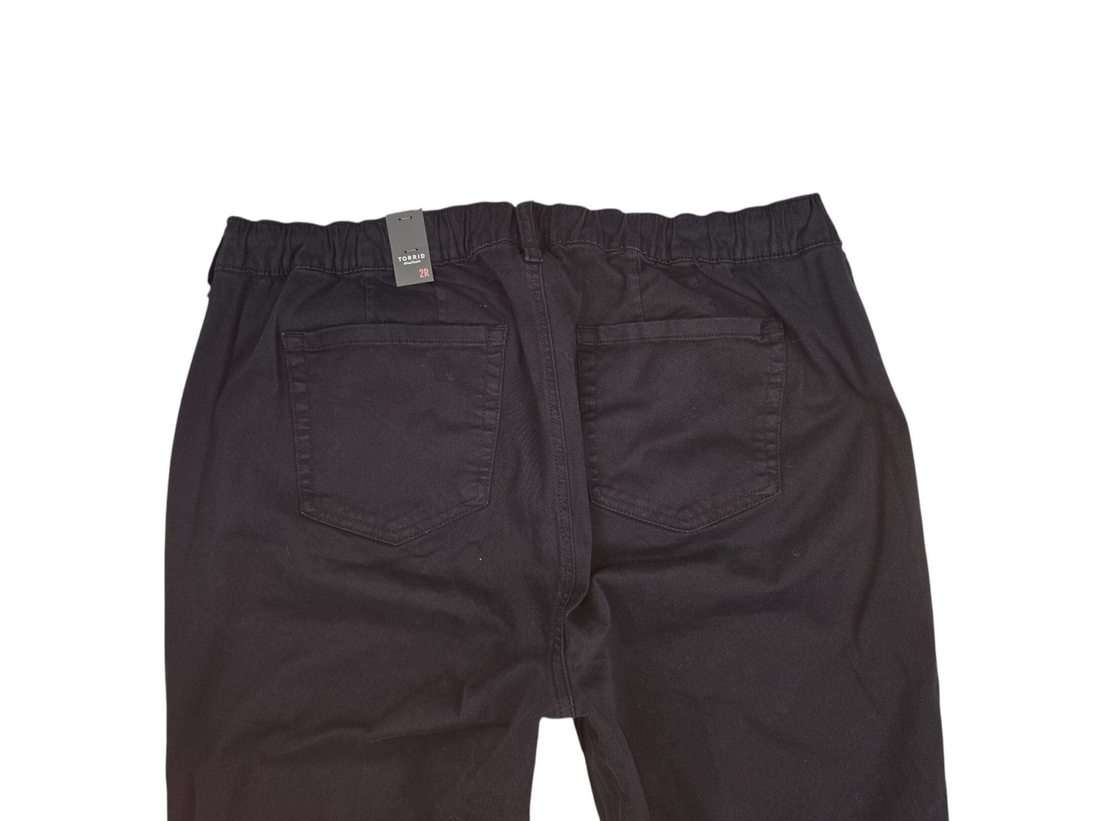 Back view of black pants with pockets and an elastic waistband.