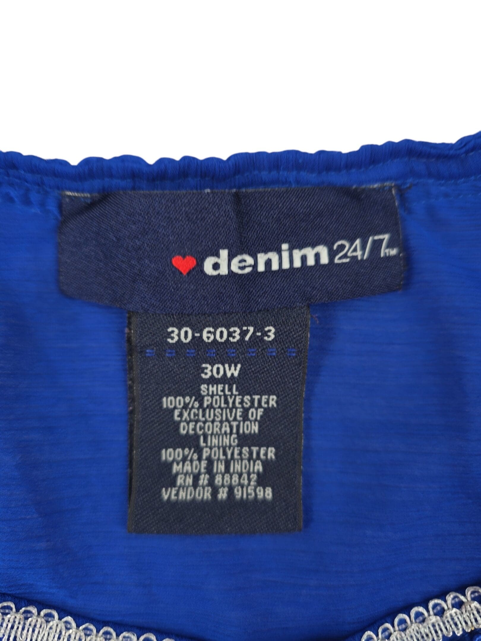 Denim 24/7 women’s blouse brand and size tag showing 30W and 100% polyester material content