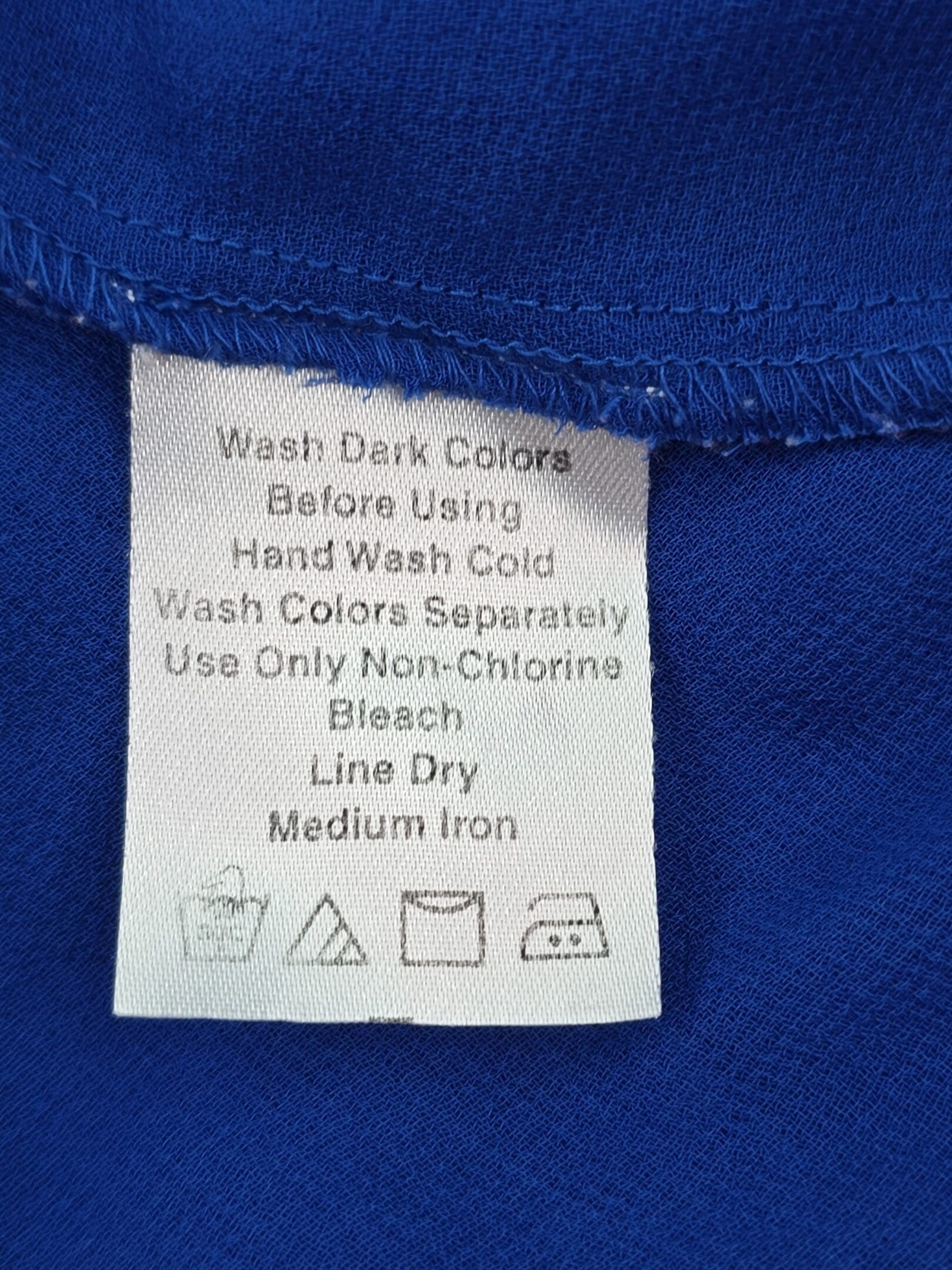 Denim 24/7 women’s blouse care tag with washing instructions for polyester fabric