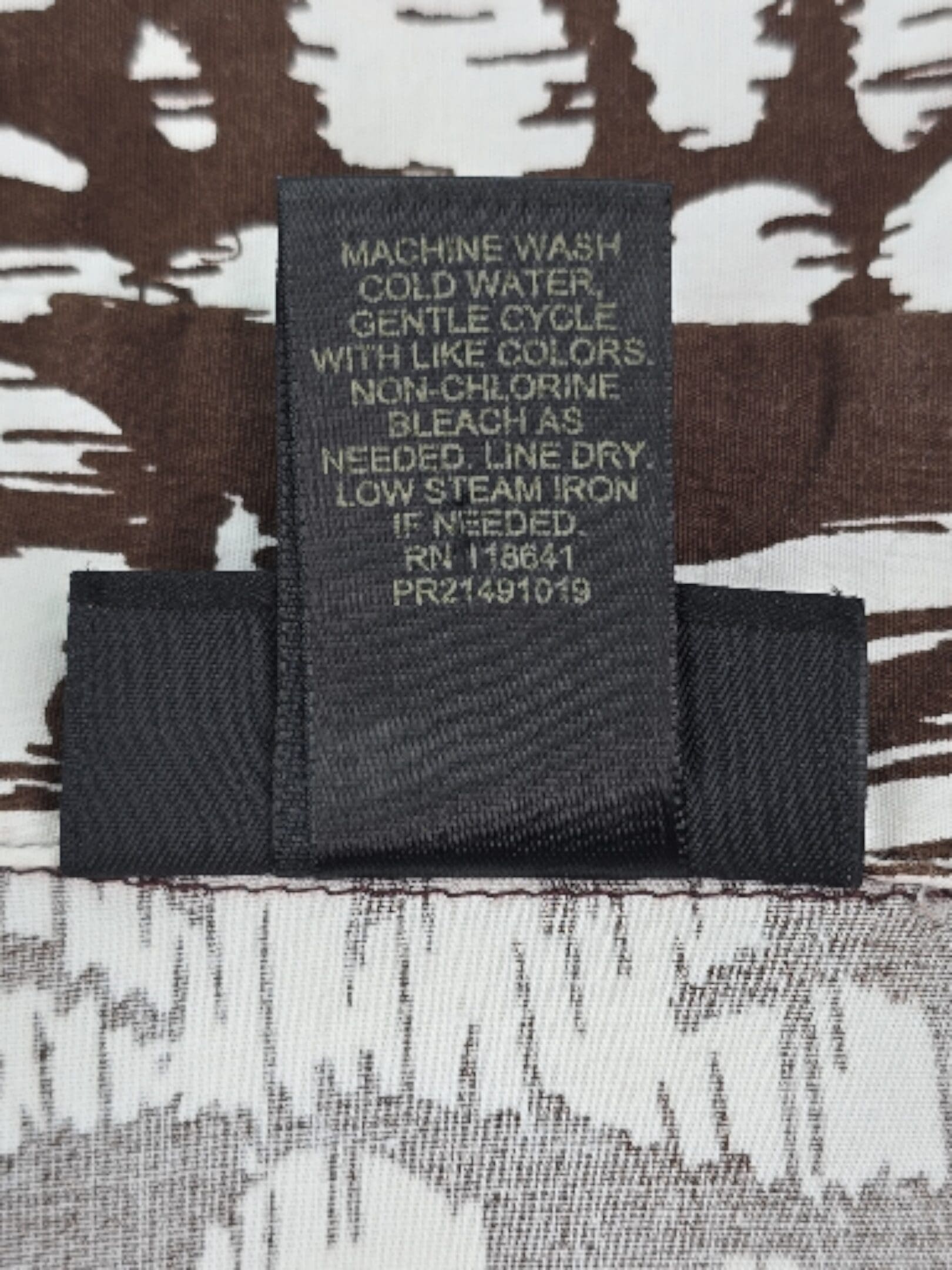 Care label for Lane Bryant brown and white shirt with washing instructions